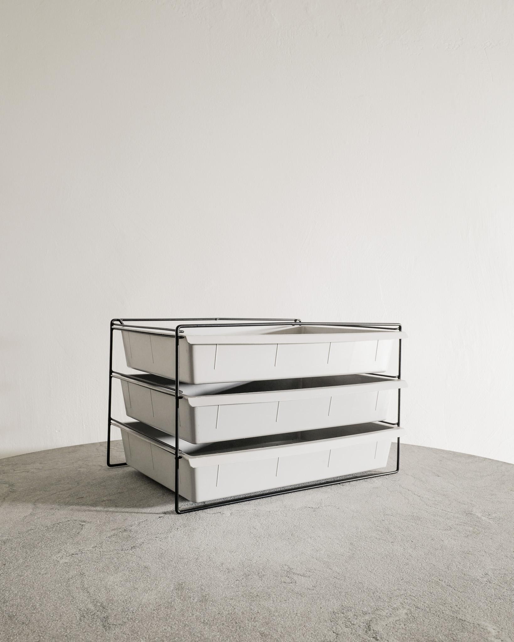 Raro archivio/portariviste francese di metà secolo con tre cassetti in plastica stampata grigio chiaro e un supporto in metallo laccato nero di Charlotte Perriand prodotto negli anni '50 per e con il marchio Charlotte Perriand/Brevete S.G.D.G..
In