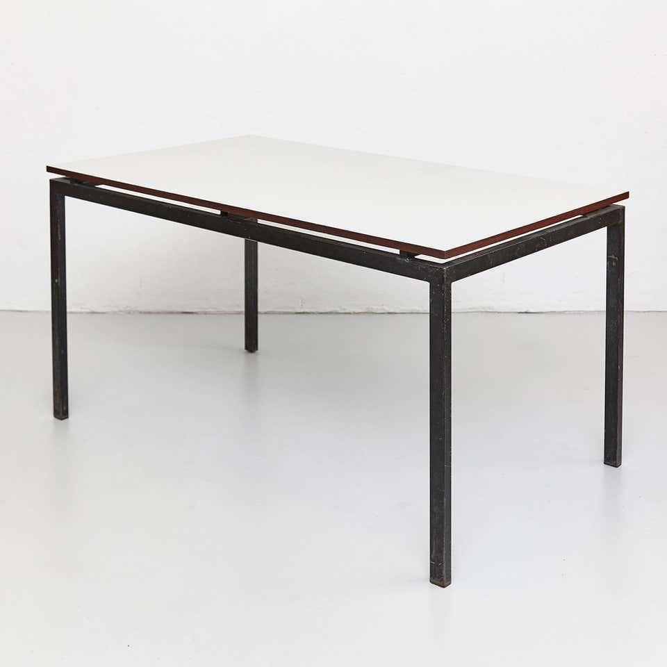 Table designed by Charlotte Perriand, circa 1950.

Wood with formica, metal frame legs.

Provenance: Cansado, Mauritania (Africa).

In good original condition, with minor wear consistent with age and use, preserving a beautiful