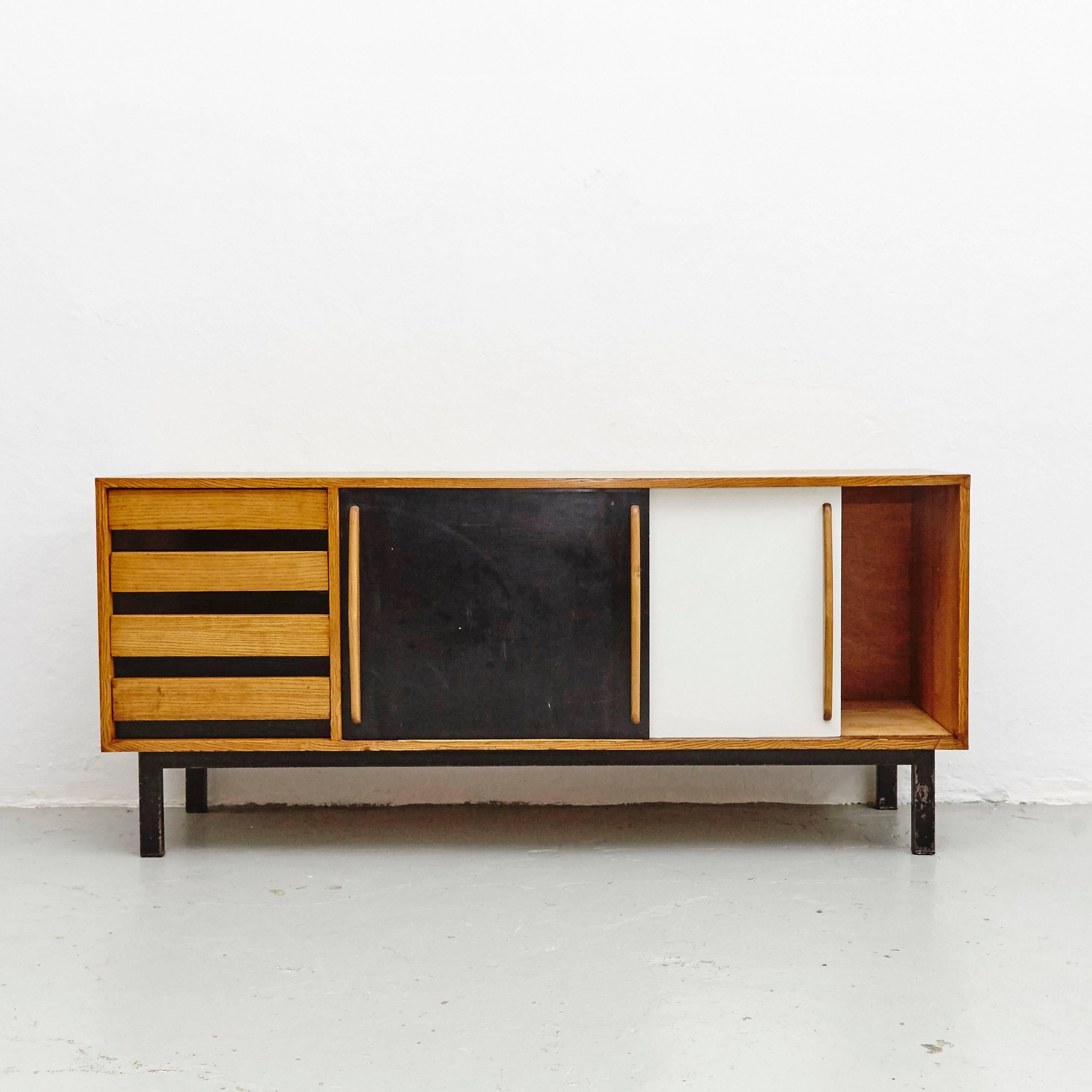 Sideboard designed by Charlotte Perriand, circa 1950.
Edited by Steph Simon, France.
Steel base, wood structure and grips, lacquered sliding doors.

Provenance: Cansado, Mauritania (Africa).

In good original condition, with minor wear