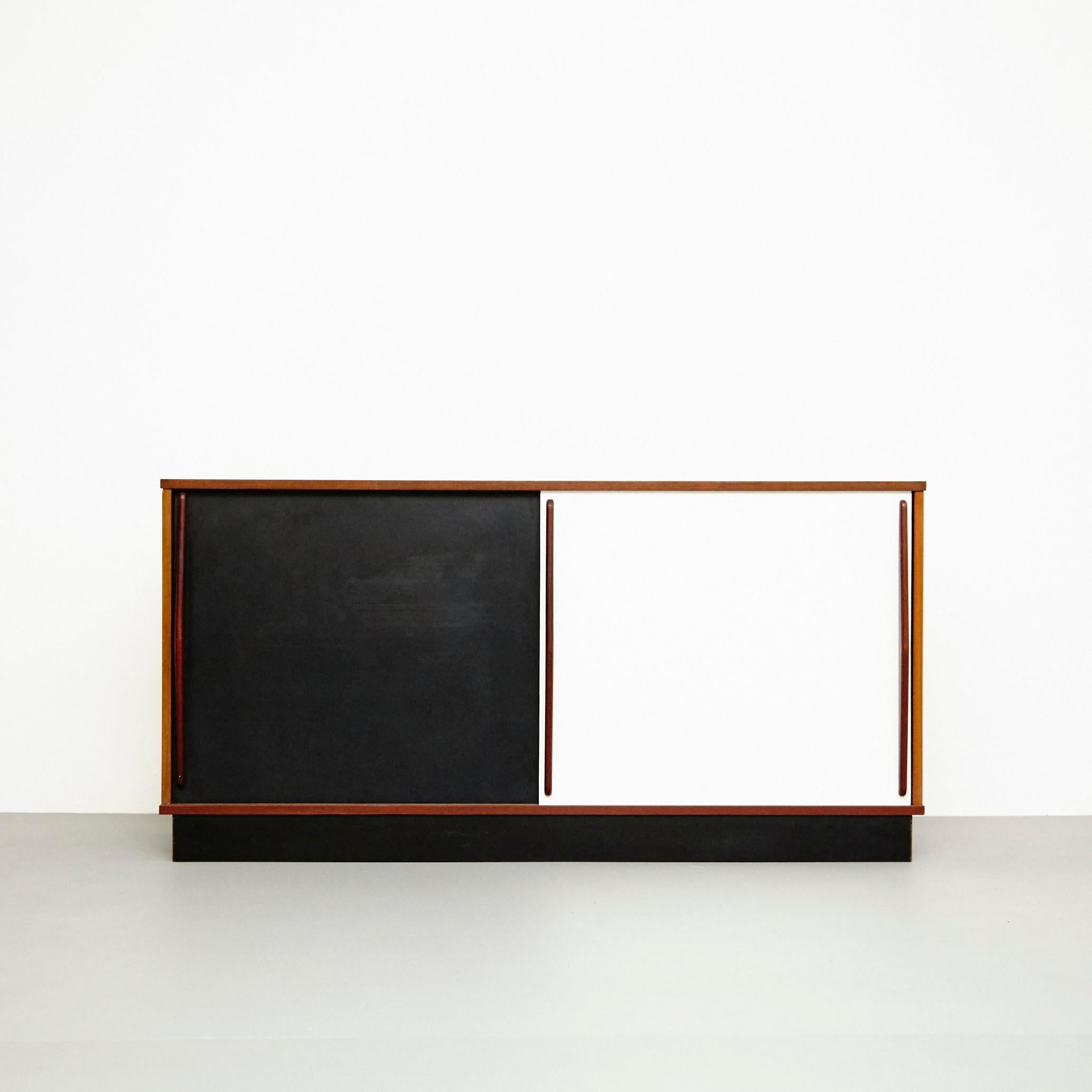 Sideboard designed by Charlotte Perriand, circa 1950.
Edited by Steph Simon, (France)

Wood structure and grips, lacquered sliding doors.

Provenance: Cansado, Mauritania (Africa)

In original condition, with wear consistent with age and use,
