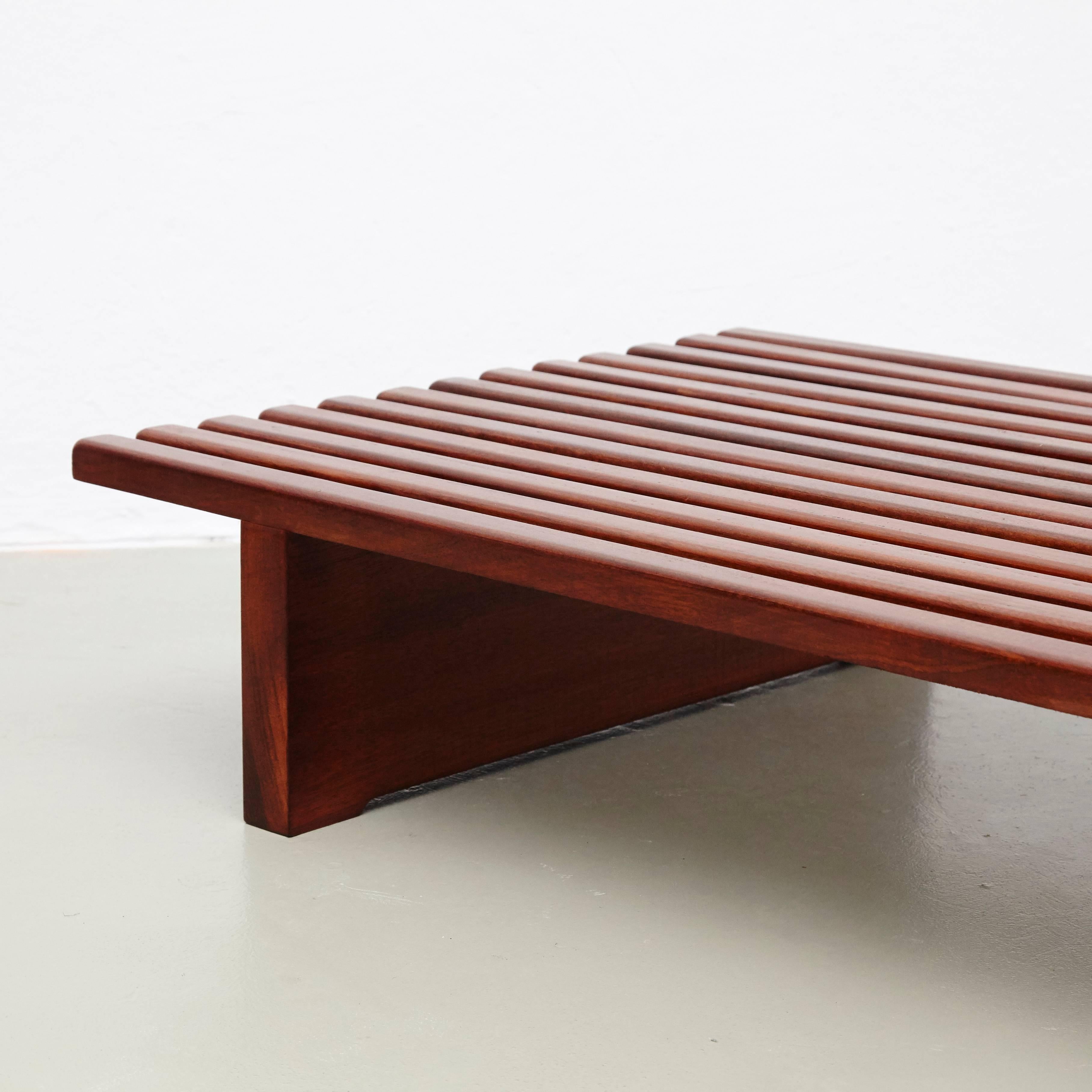 Bench designed by Charlotte Perriand, circa 1950.
This model is with 13 slats of wood.

Mahogany wood base and structure.

Wooden legs seems to be latter added by previous owner.

Provenance: Cansado, Mauritania (Africa).

In good original