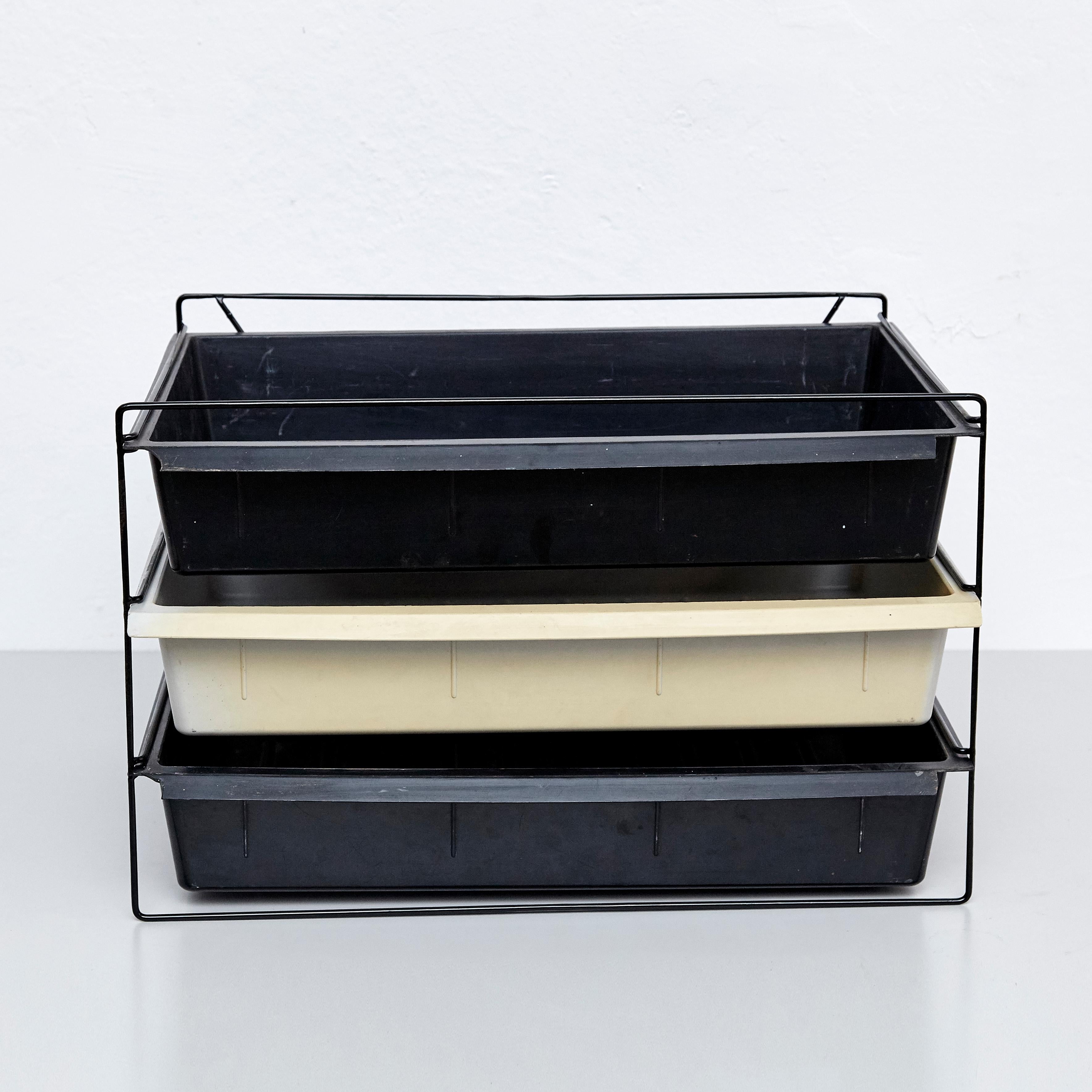 File rack designed by Charlotte Perriand, circa 1950.
Manufactured in France, circa 1950.
Moulded plastic and painted metal.

Each drawer moulded with Modele Charlotte Perriand or Brevete S.G.D.G.

In original condition, with minor wear