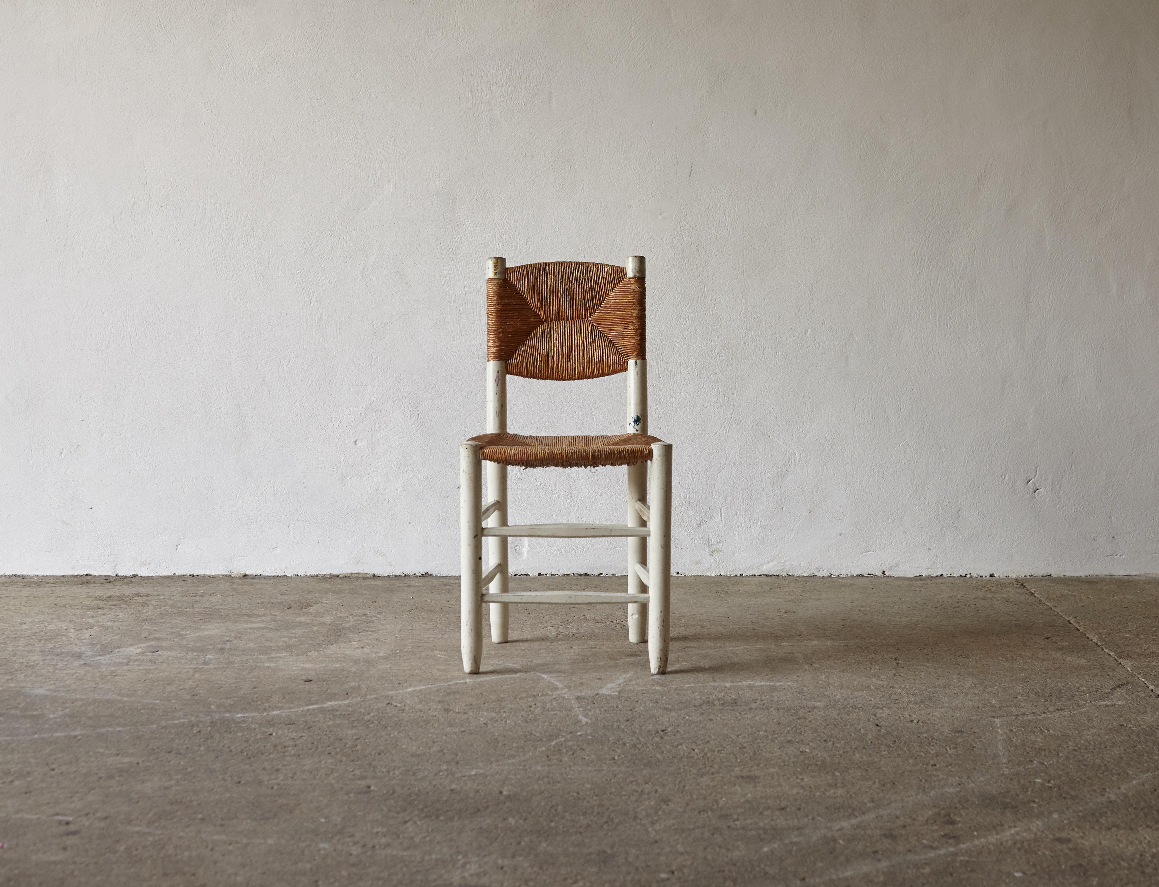 Superbe chaise Bauche modèle 19 de Charlotte Perriand, France, années 1950. Cadre en bois repeint en blanc dans un passé lointain. Plein de caractère. Bon état structurel avec le jonc d'origine. Expédition rapide dans le monde entier.
