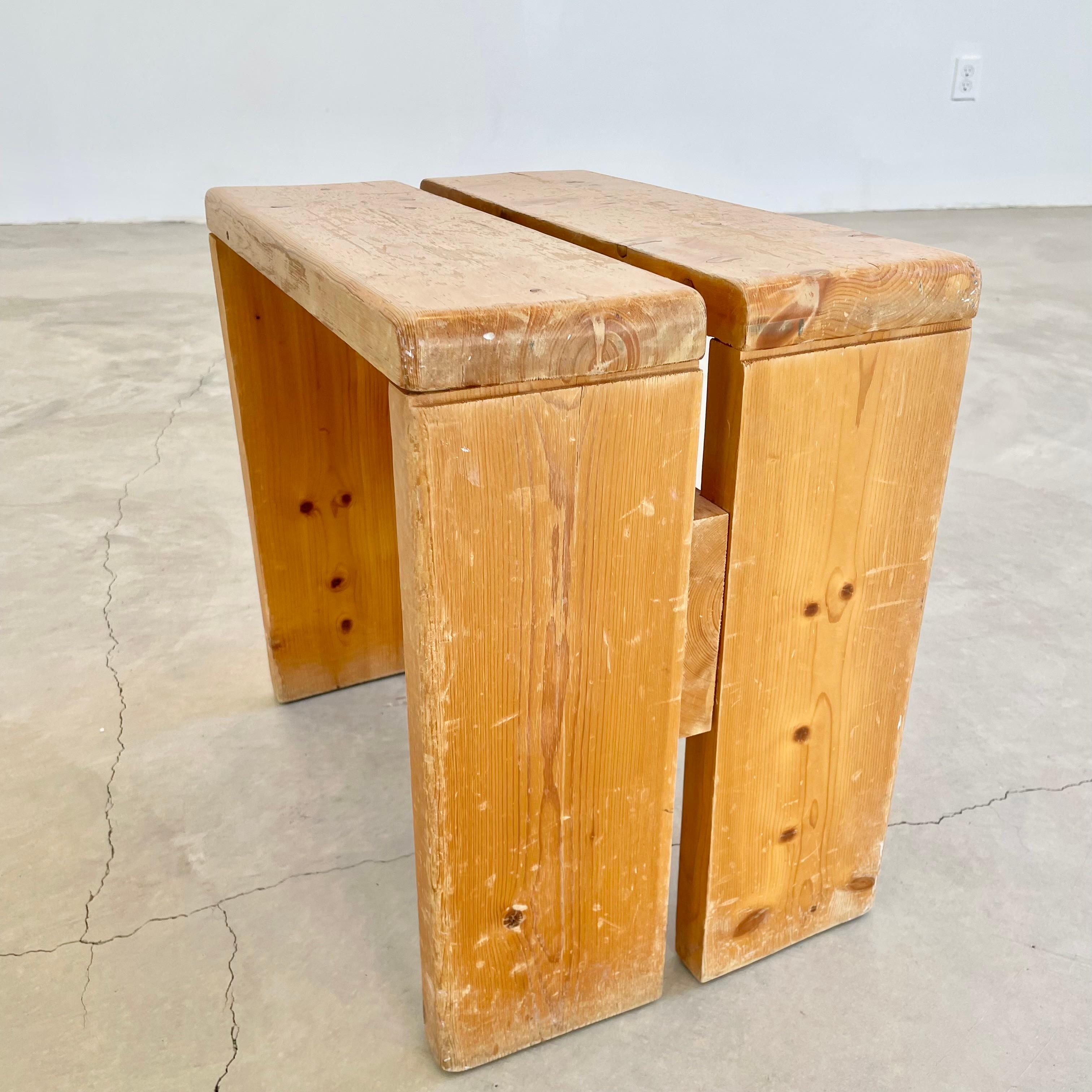 Tabouret classique en pin conçu par Charlotte Perriand pour la station de ski des Arcs, en France. De grandes lignes et une simplicité commune aux dessins de Perriand. Une traverse en bois sous le siège et deux montants en pin dans le siège de