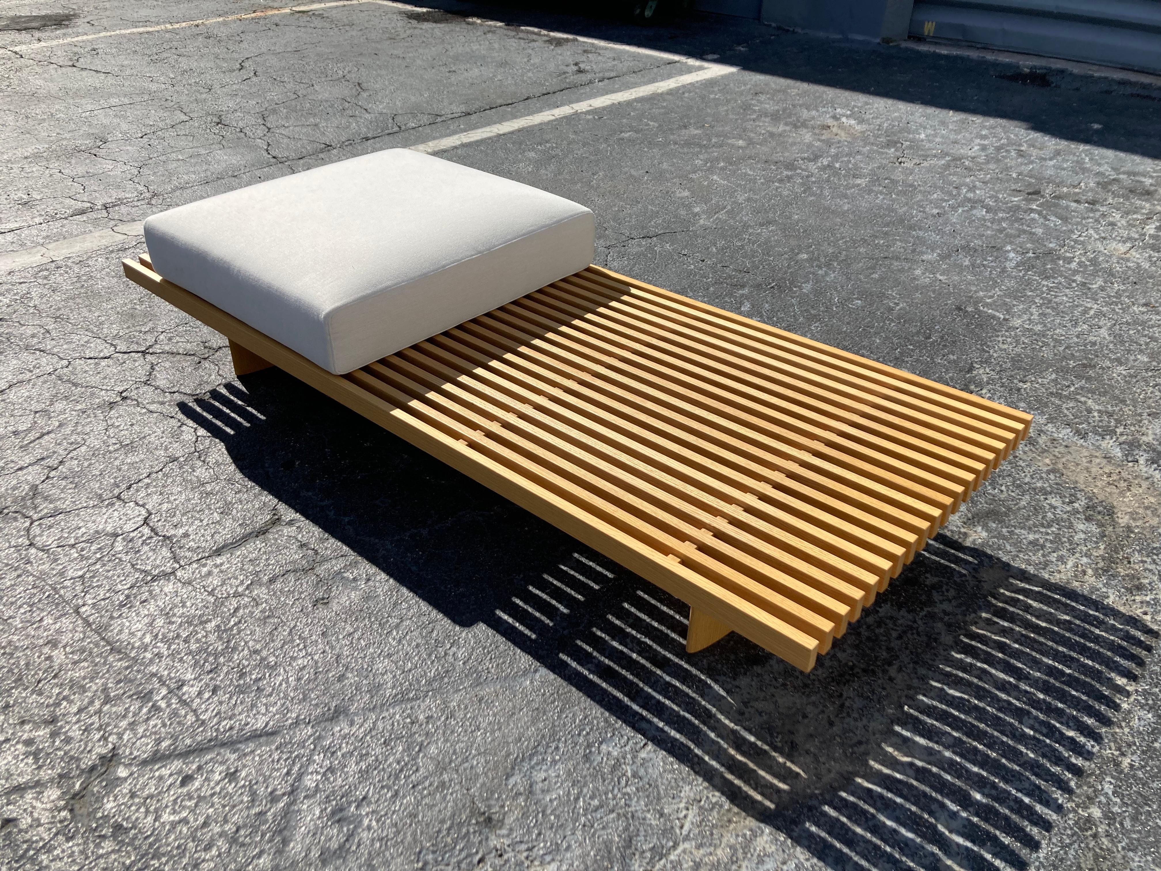 Refolo bench designed by Charlotte Perriand in 1953. Relaunched by Cassina in 2004. Manufactured by Cassina in Italy, comes with two original cushions. The oak wood and fabric have some normal wear.