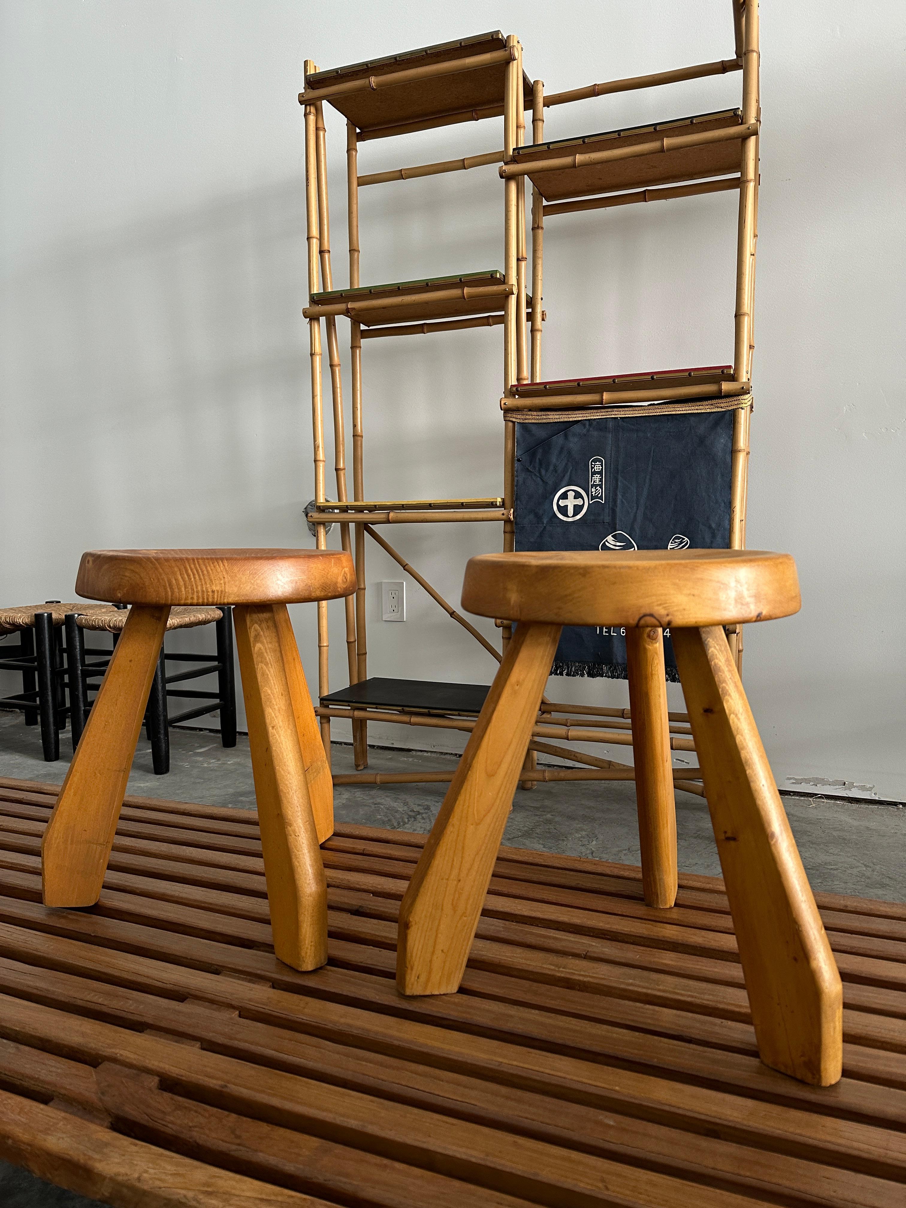 A pair of eye-catching pine stools with a thick round seat and unique tripod legs. The wood has a beautiful natural aged patina. The ‘Sandoz’ stool was originally designed, circa 1955, and was used in Perriand’s own chalet in Meribel. In 1962 she