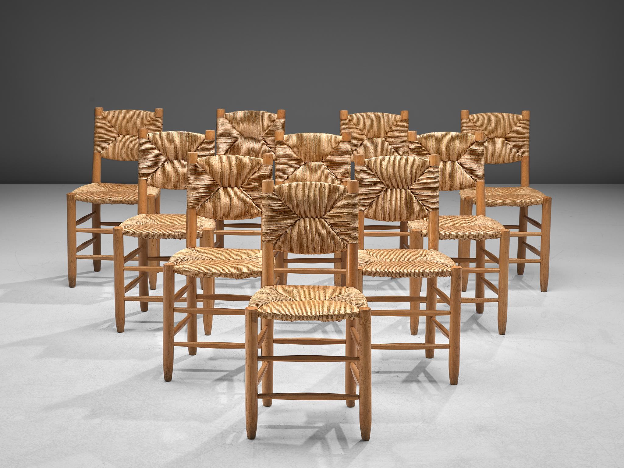 Charlotte Perriand edited by Steph Simon, set of 10 'Bauche' chairs N19, ash and cane, France, 1950s.

Rustic and naturalist set of dining chairs executed in ashwood and wicker. Charlotte Perriand created this model with an inclined back in 1939
