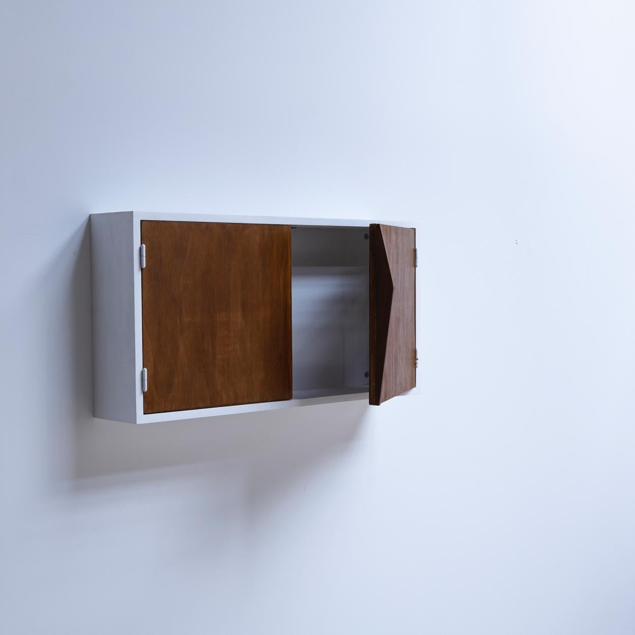 A wooden wall cabinet with the doors that designed by Charlotte Perriand and manufactured by Ateliers Jean Prouvé. The doors were originally used as the indoor storage facade.
Provenance: Le Couteur building, rue Courboulay, Le Mans,