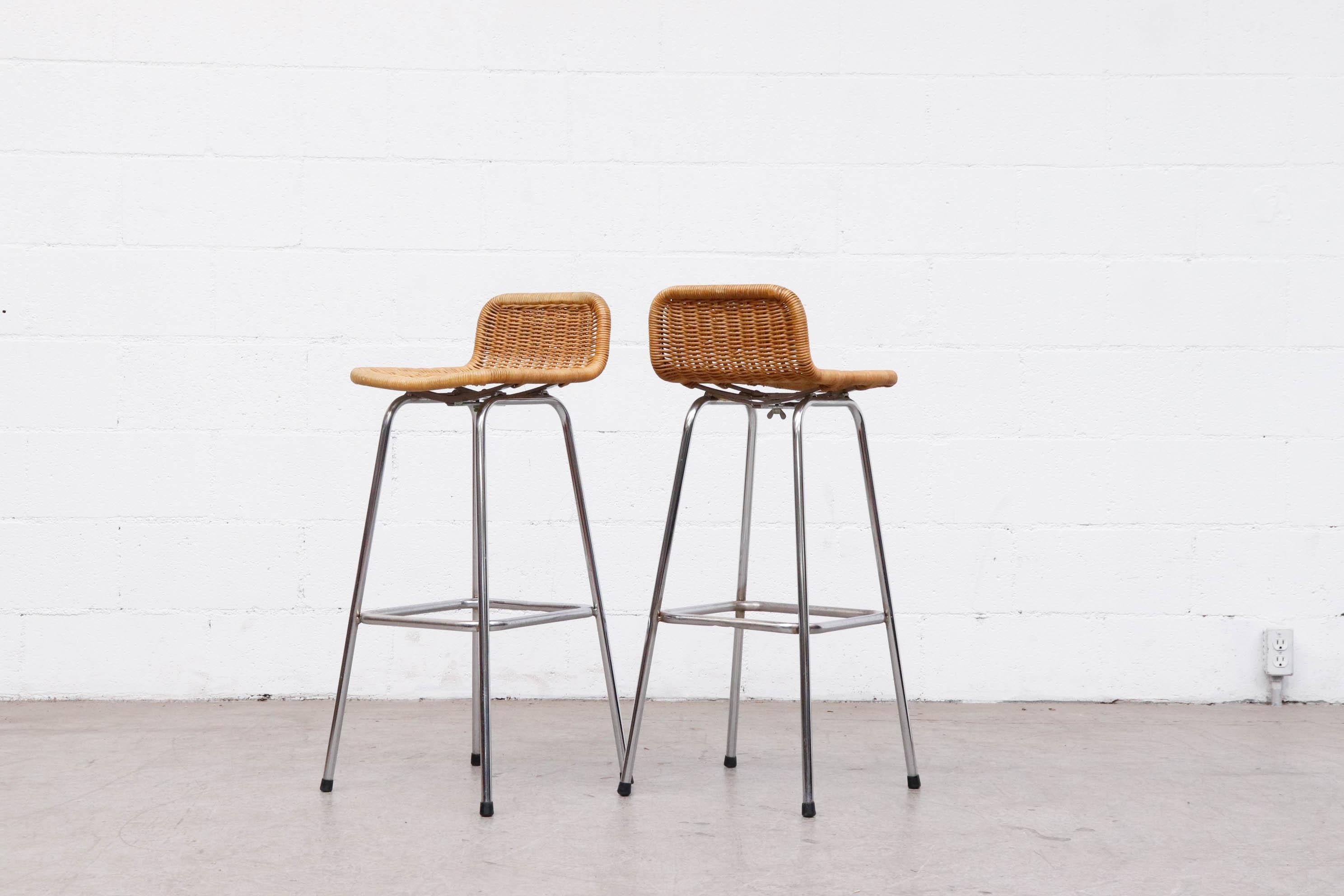 Pair of Charlotte Perriand style bar stools by Dirk van Sliedregt for Rohe Noordwolde with low Rounded Rattan seat backs, Chrome Tubular frames and bolted down seats. In original condition with visible wear and patina, consistent with age and use.