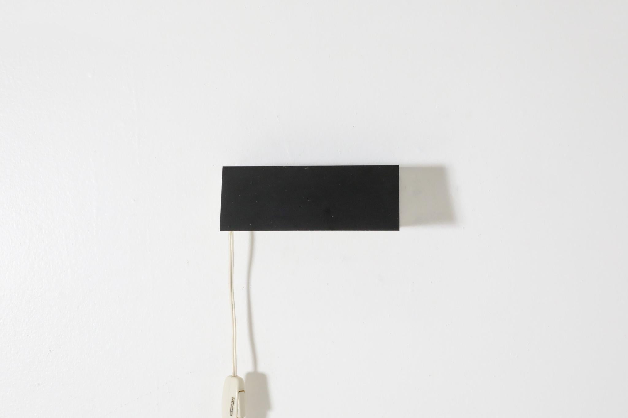 Charlotte Perriand style rectangular flush mount wall sconce with white base and black front. In original condition with visible wear including scratches. Wear is consistent with its age and use.