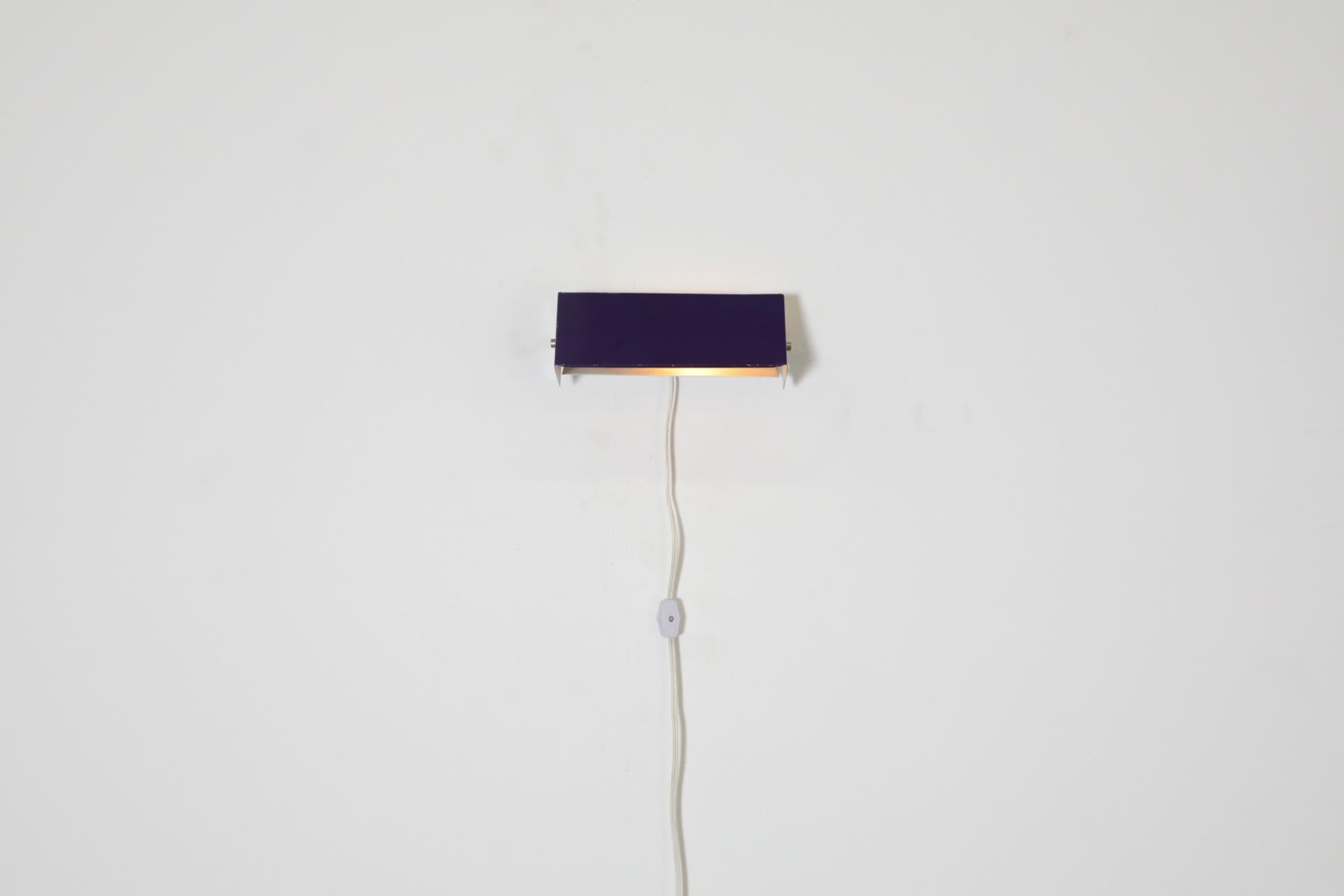 Mid-Century wall mount sconce with purple enameled shade that adjusts for directional light and to reduce glare. This elegant Dutch style sconce is in original condition with age appropriate wear and some visible enamel loss. Comes with a US