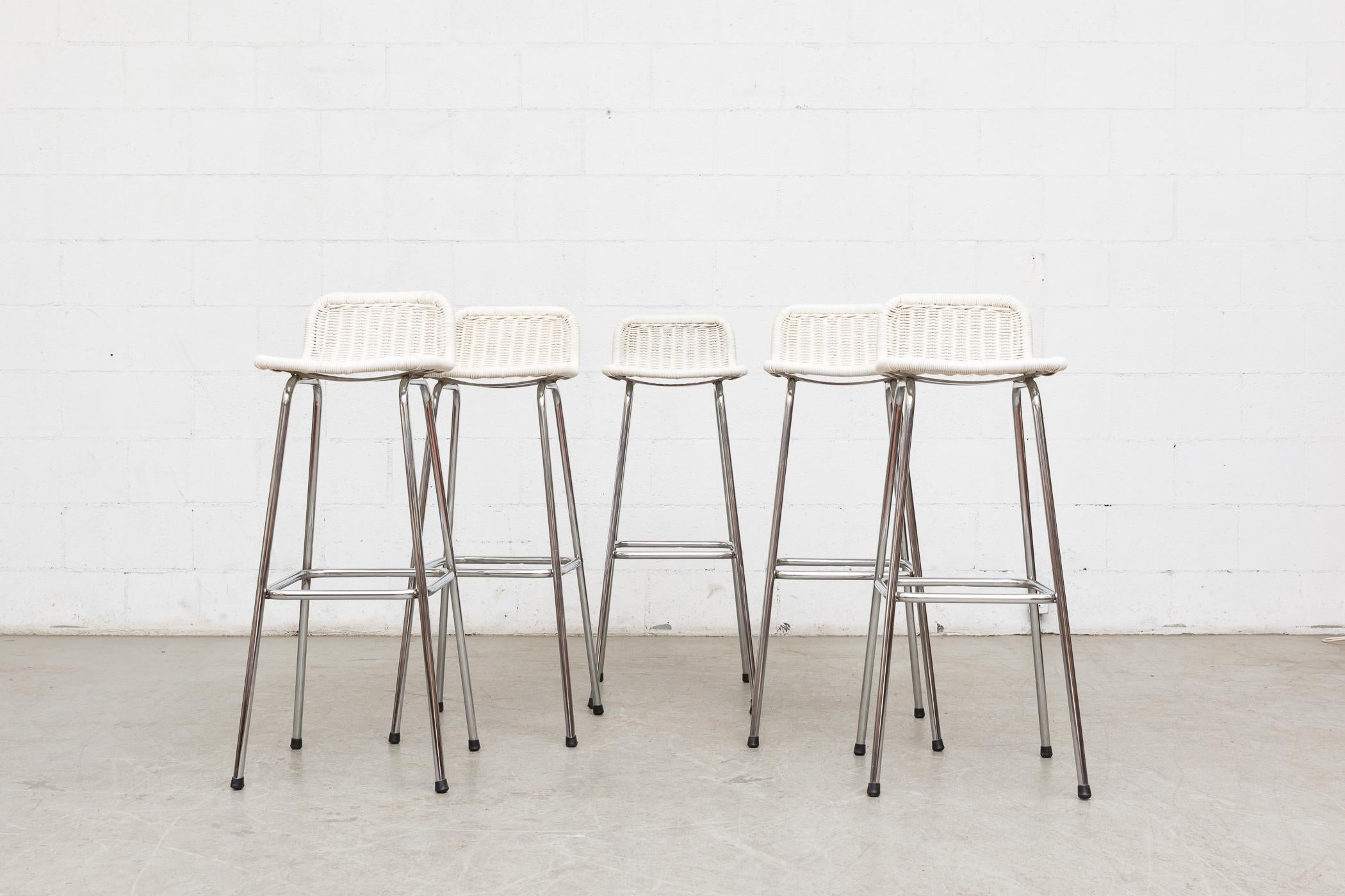 Charlotte Perriand style bar stools. White painted rattan seats on chrome tubular frames. Frames in original condition, seats were over-painted in the 1970s by original owner. Wear Consistent with its age and usage.