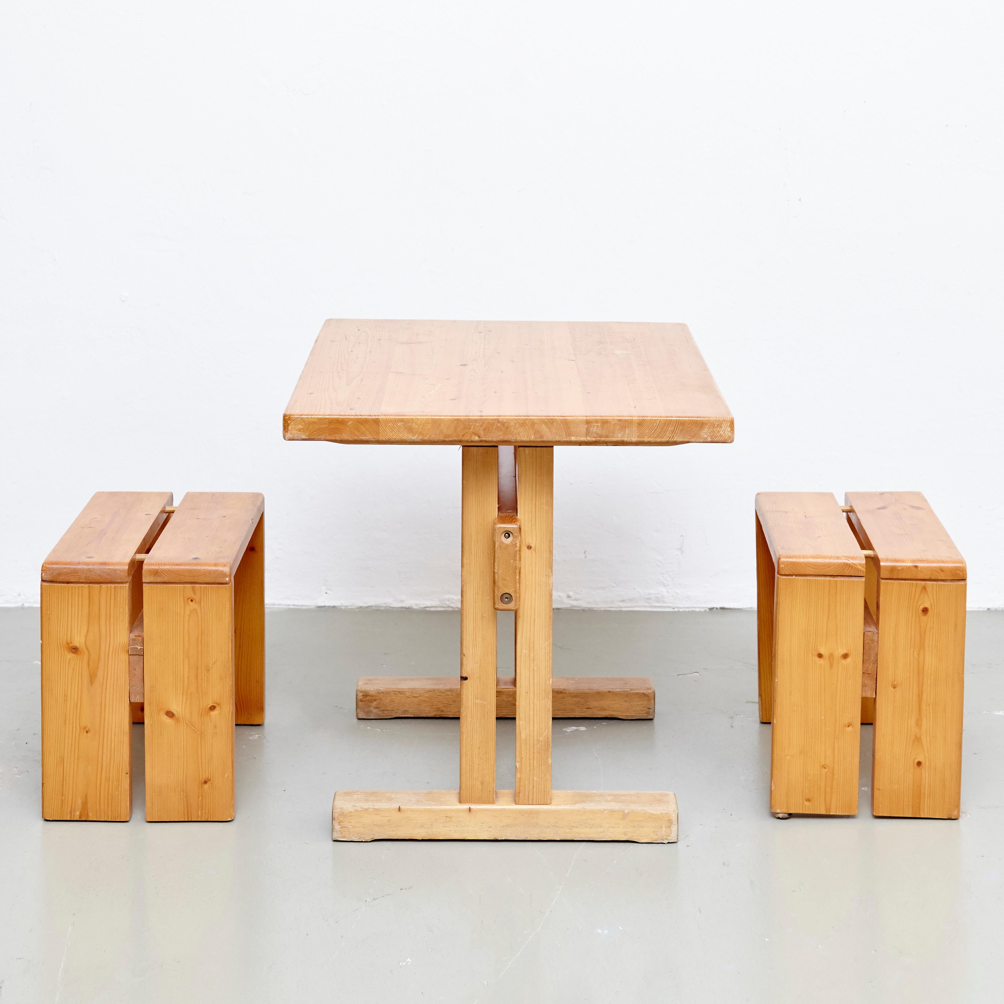 Set of table and stools designed by Charlotte Perriand for Les Arcs ski Resort circa 1960, manufactured in France.

Pinewood.

In original condition, with minor wear consistent with age and use, preserving a beautiful patina.

Measure: Table