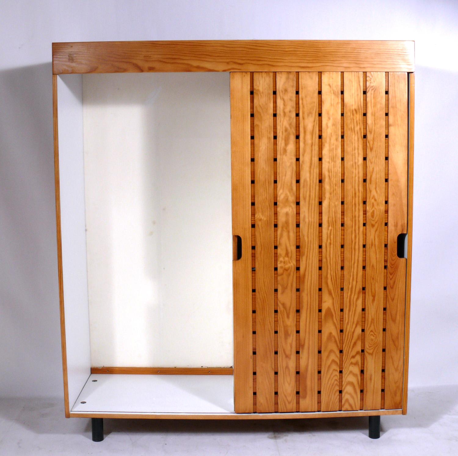 Charlotte Perriand wardrobe from Les Arcs Ski Lodge, France, circa 1960s. It offers a voluminous amount of storage with the single door sliding to reveal one large compartment on the left, and two large compartments on the right, one with shelves,