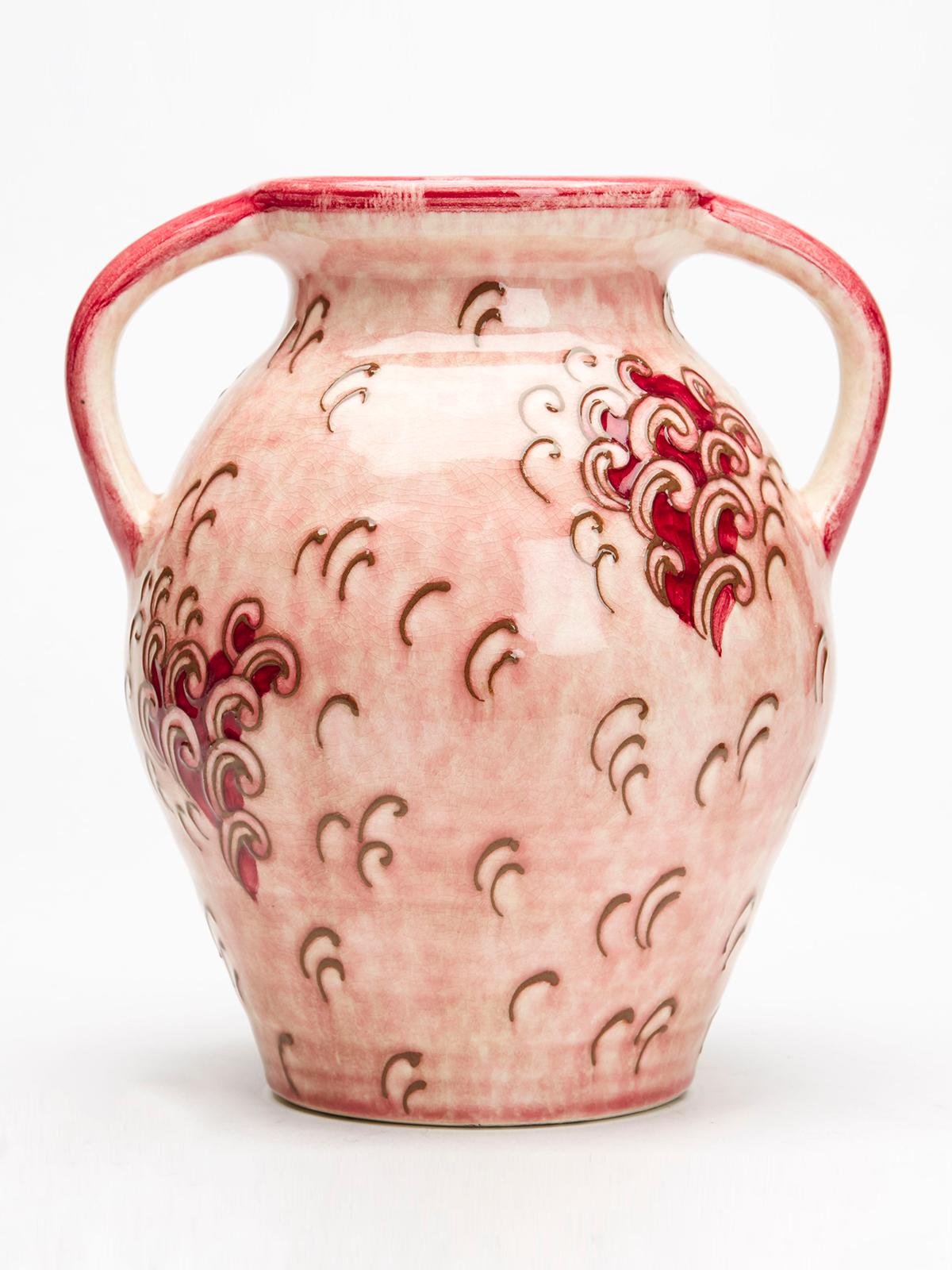 An unusual Art Deco Bursley Ware twin handled art pottery lamp base decorated with tube lined designs on a pink ground by renowned English designer Charlotte Rhead (British, 1885-1947). The bulbous earthenware lamp base is purpose made and of