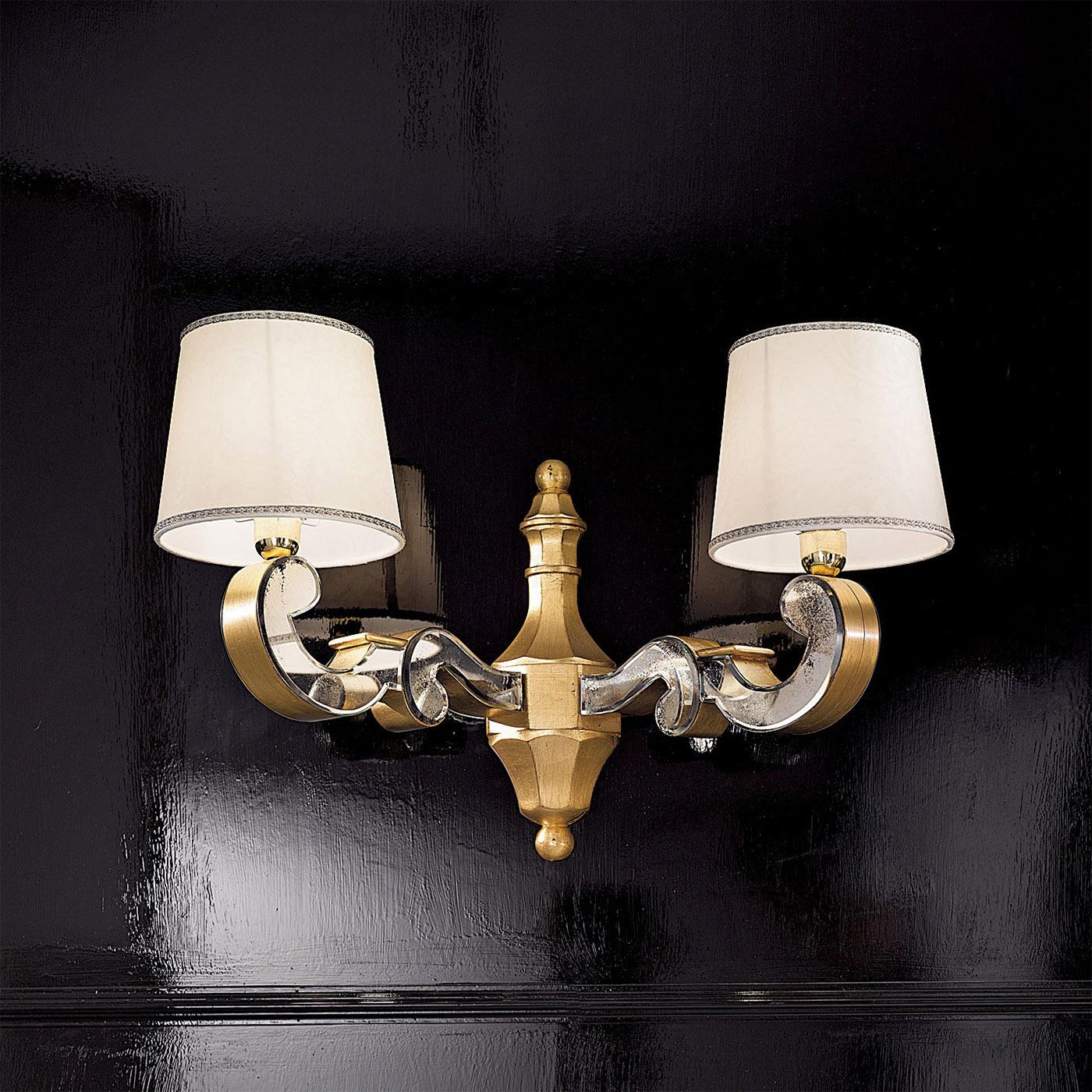 Part of the Notre Dame collection, the Charlotte sconce is inspired by the Art Deco period. This wall lamp features two lights and a wooden structure finished in golden leaf and hand-beveled antiqued mirror.