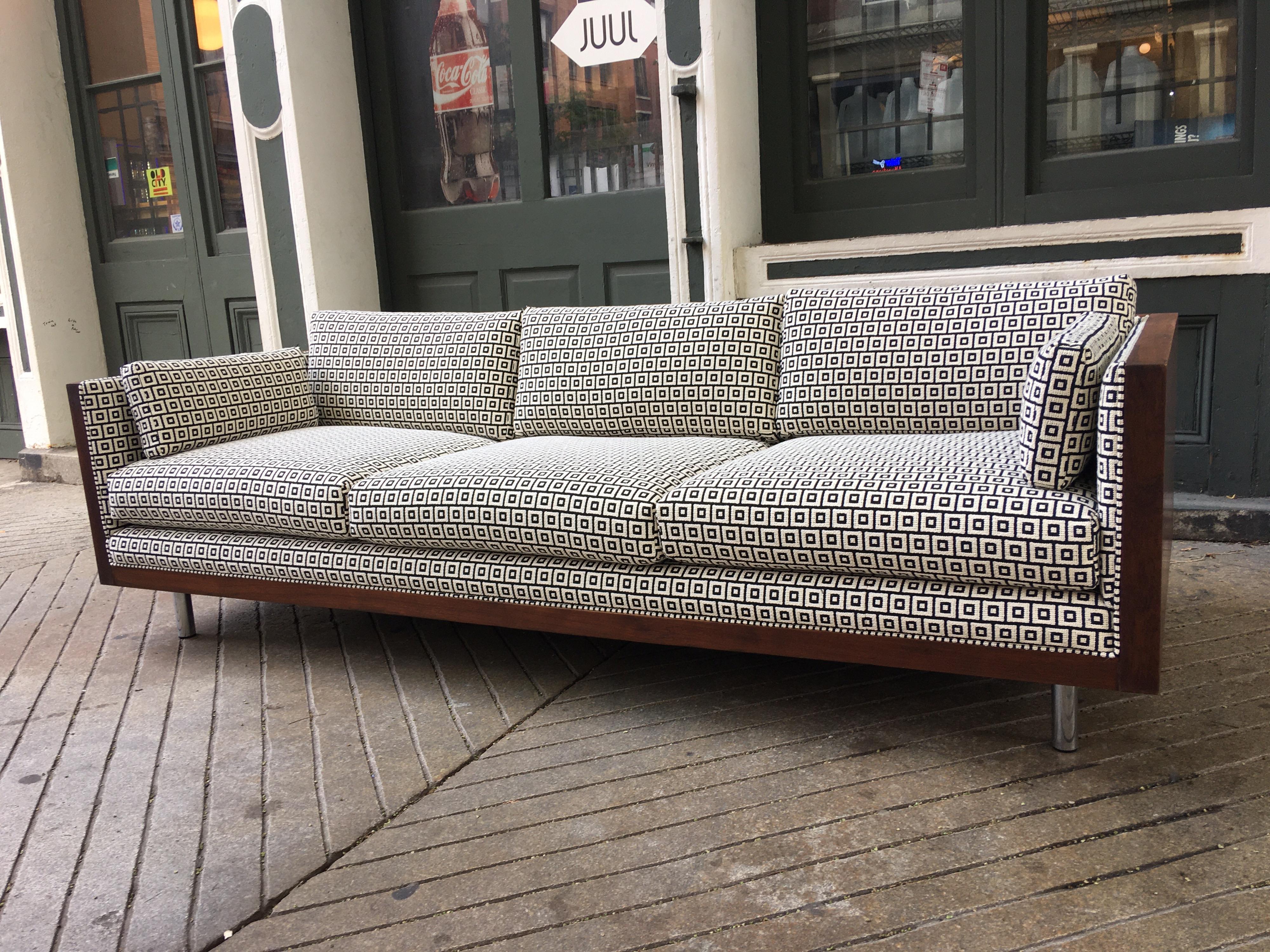 Charlton floating walnut box sofa! Newly reupholstered with a cream and black Lee Jofa fabric. Sofa sits on 4 round chrome legs which gives the sofa a floating appearance. Sofa is finished all around which makes it perfect for sitting in the middle