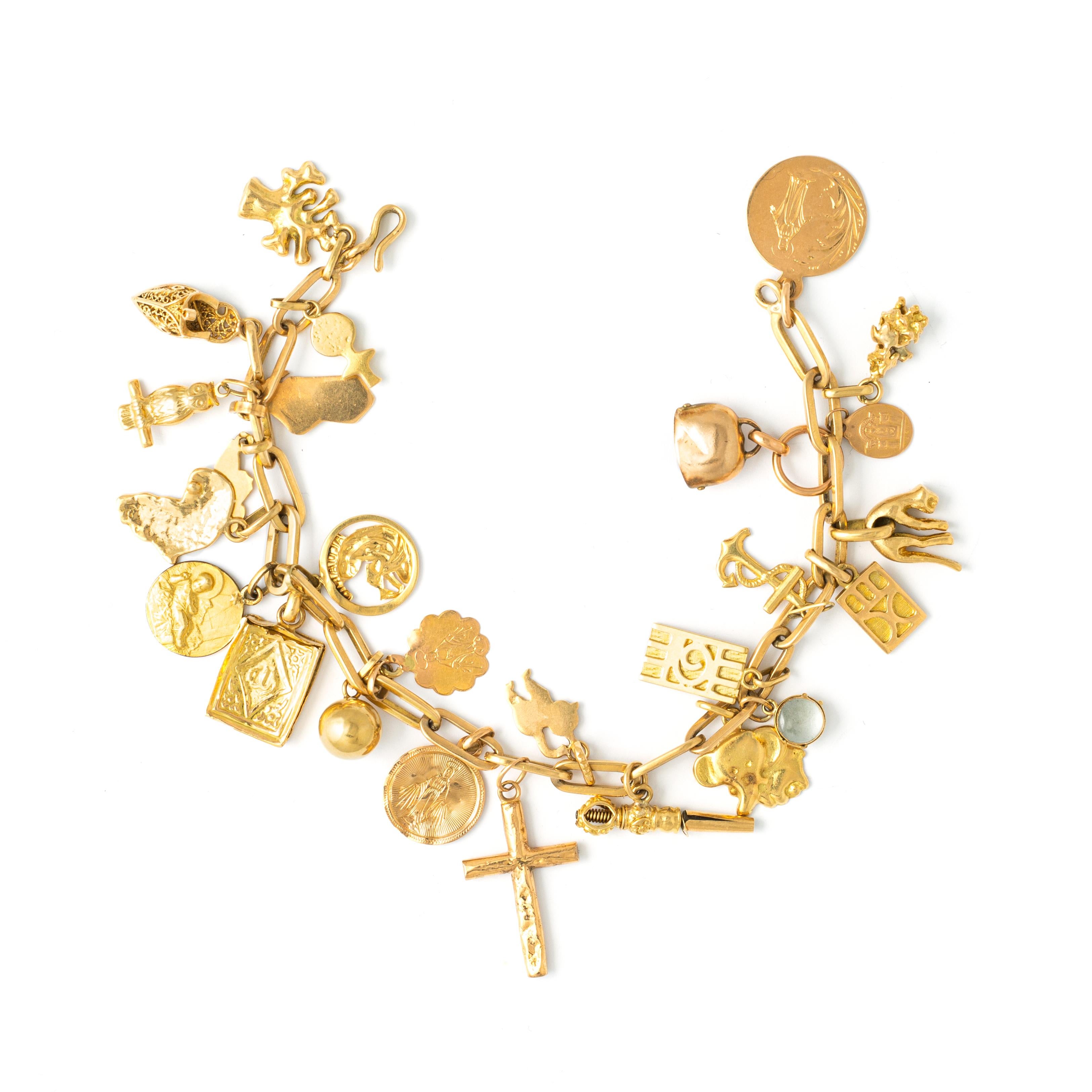 Bracelet in yellow gold 9K, 14K and 18K retaining numerous pendant and charms representing various symbols. 
Late 20th Century.
Length: 20.50 cm. 
Gross weight: 43.40 grams.