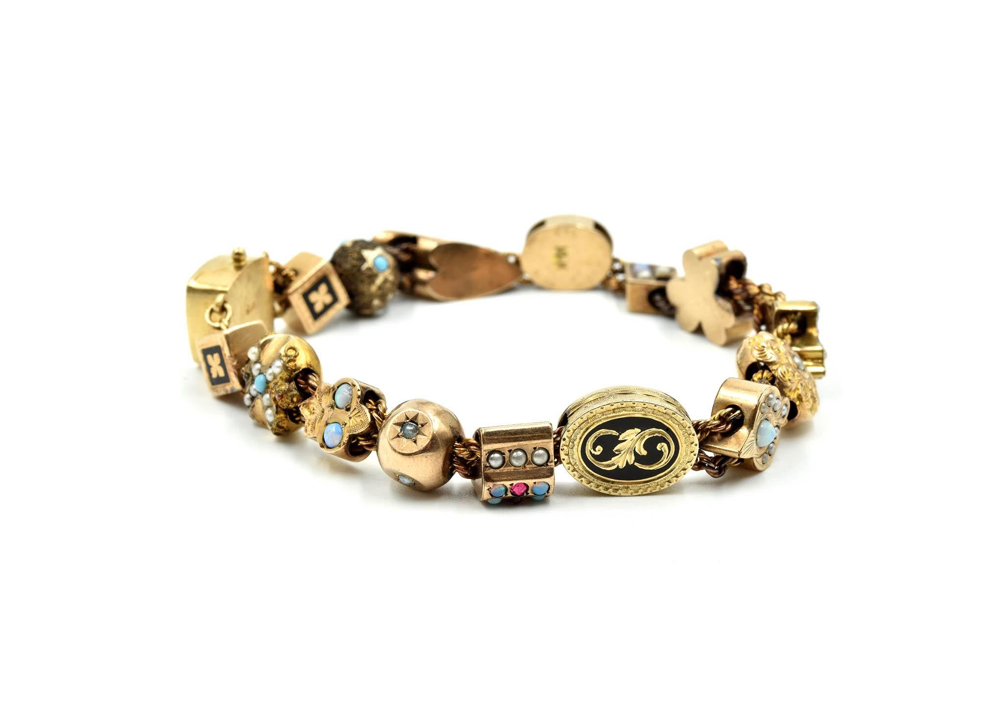 This stunning vintage charm bracelet is made in 14k and 10k yellow gold. The bracelet crafted in both 14k and 10k yellow gold. The charms are made in varying shapes with beautiful colored stones. The bracelet measures 7 ½ inches and weighs 25.2