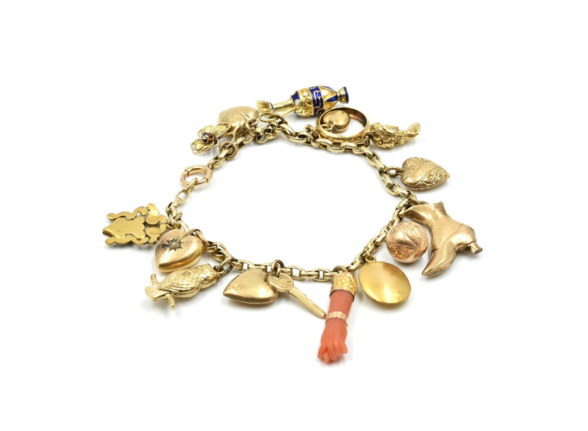 This stunning vintage charm bracelet is made in 14k and 10k yellow gold. The bracelet is 10k yellow gold and the charms on the bracelet dangle from the oval links are crafted in both 14k and 10k yellow gold. The charms include hearts, flowers,