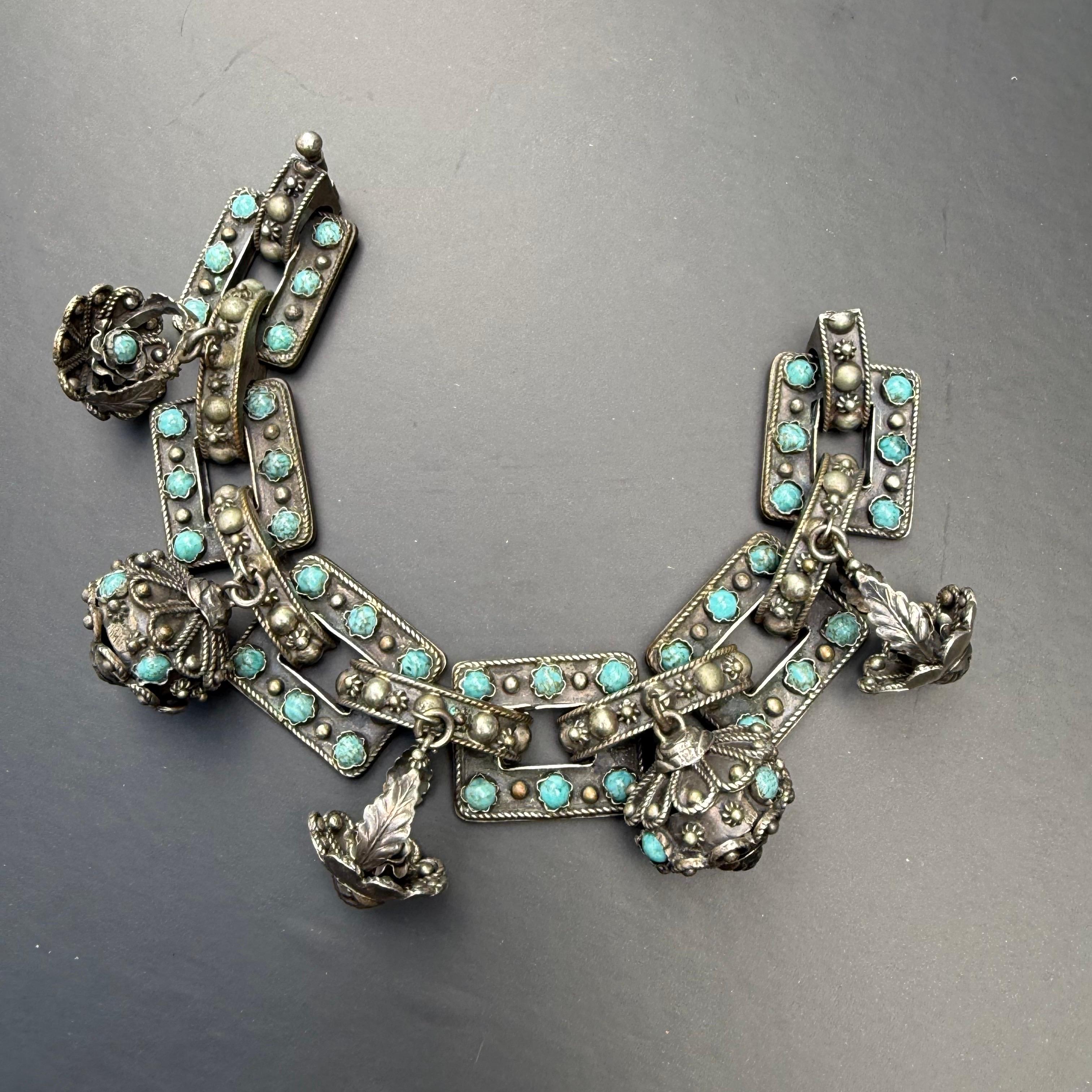 Exemple exquis de bijoux italiens de style néo-étrusque, ce bracelet à breloques vintage en argent 800 présente une large chaîne ornée de cinq breloques réalisées avec soin. Chaque breloque est ornée d'un travail de fil métallique détaillé,