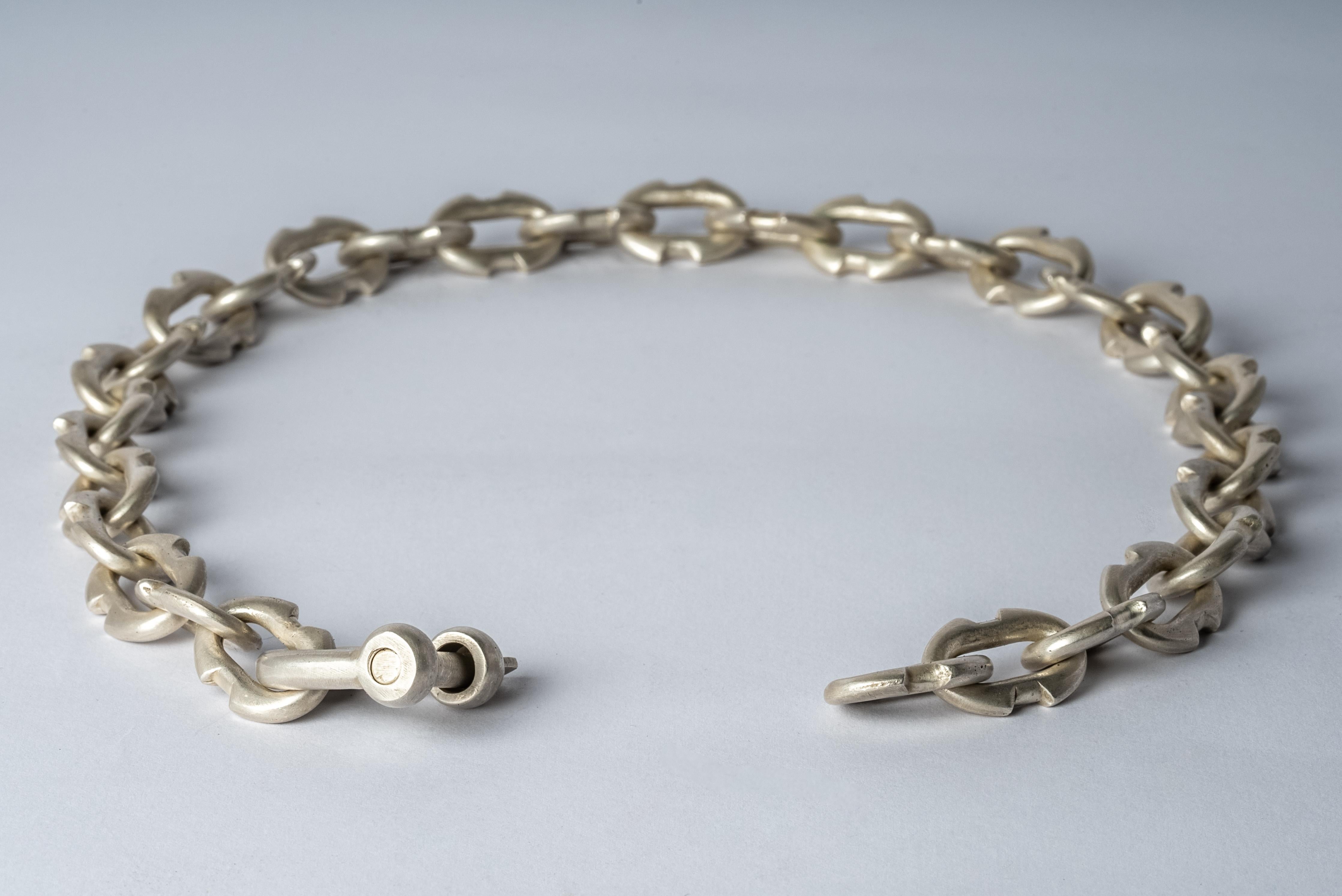 Halskette mit Charme aus Messing. Das Messing-Substrat wird galvanisch mit Silber beschichtet und dann in Säure getaucht, um die subtil zerstörte Oberfläche zu erzeugen.
Das Charm System ist eine zusammenhängende Gruppe von Produkten, die gemischt