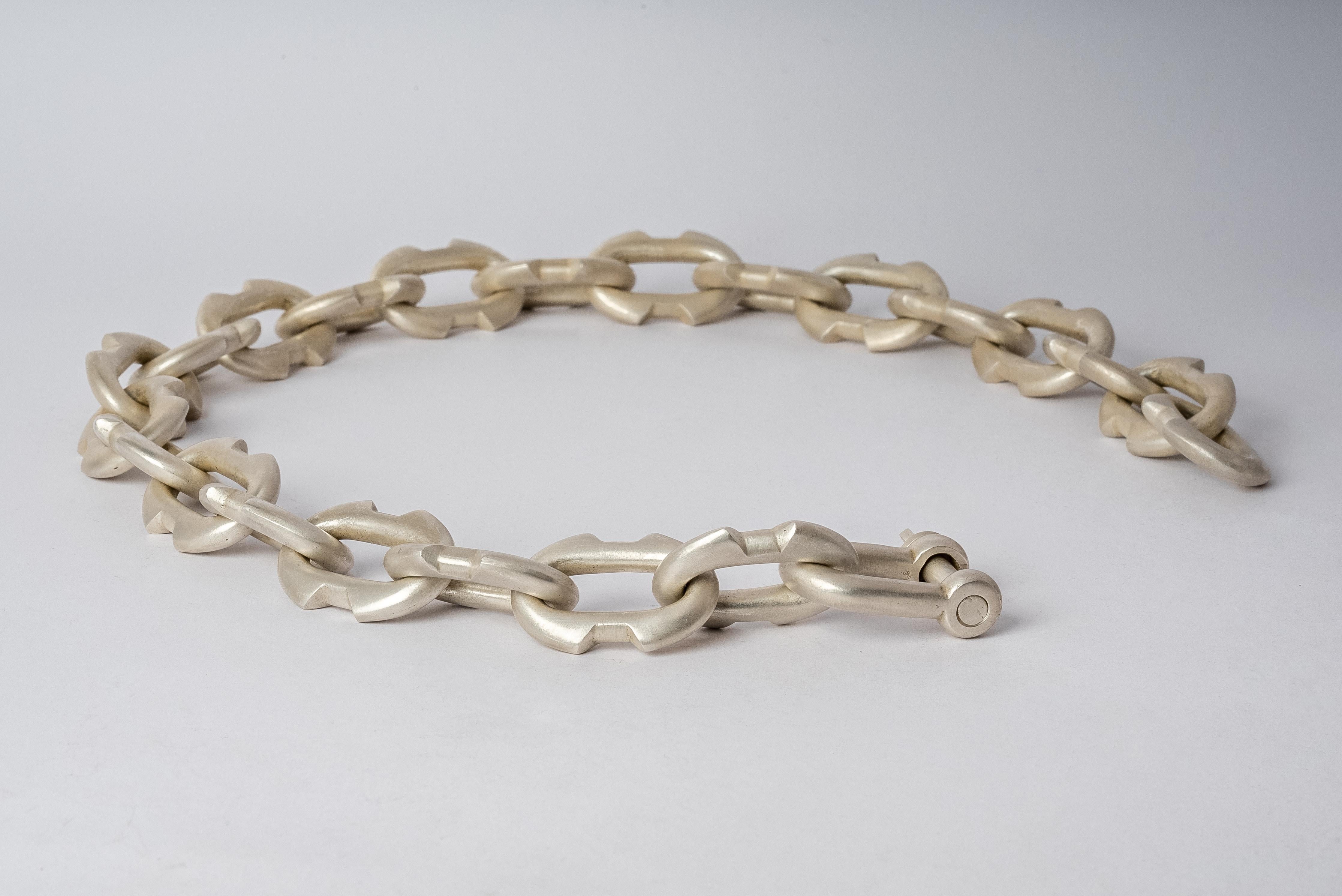 Charm chain necklace in brass. Brass substrate is electroplated with silver and then dipped into acid to create the subtly destroyed surface. 
The Charm System is an interrelated group of products that can be mixed and matched or worn