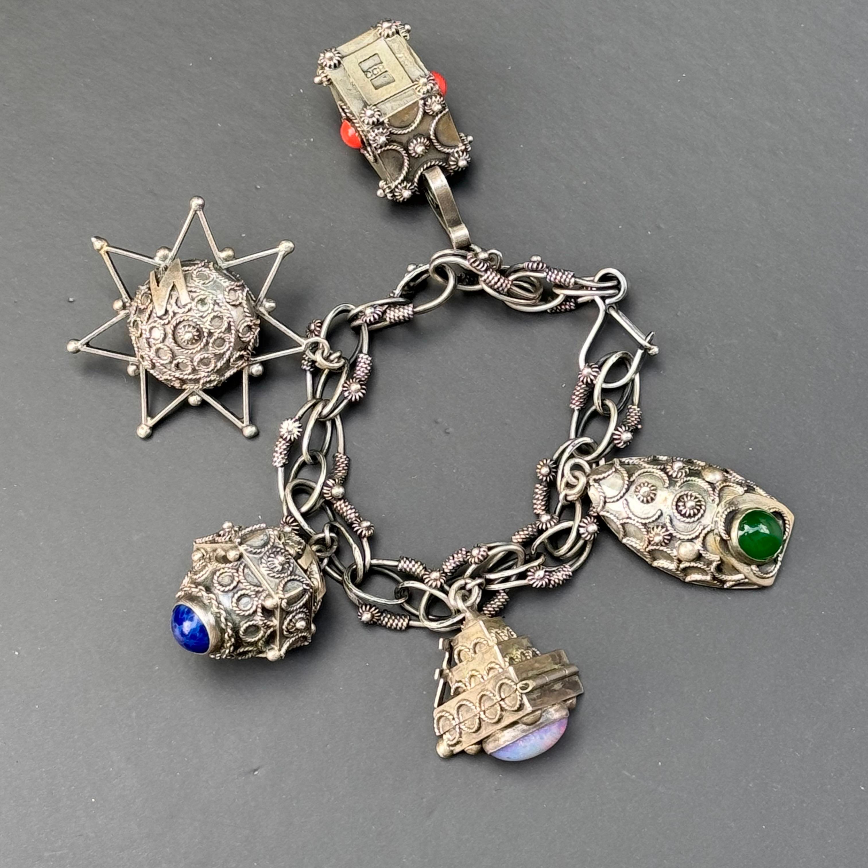 Step back in time with this exquisite mid-century vintage Victorian /Etruscan style charm /locket bracelet from Italy. Crafted in 800 silver, it epitomizes the elegance and craftsmanship of a bygone era. The bracelet features intricate detailing