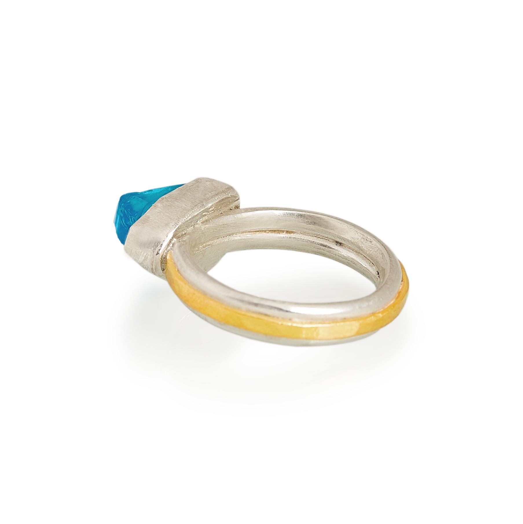 Crisp and fresh blue topaz ring made in sterling silver with a band of 18 karat gold. The topaz stone has an unusual cut that lets a lot of light through.

U.S ring size: 6 ¾
U.K size: N

British hallmarks

Please don't hesitate to contact us if you