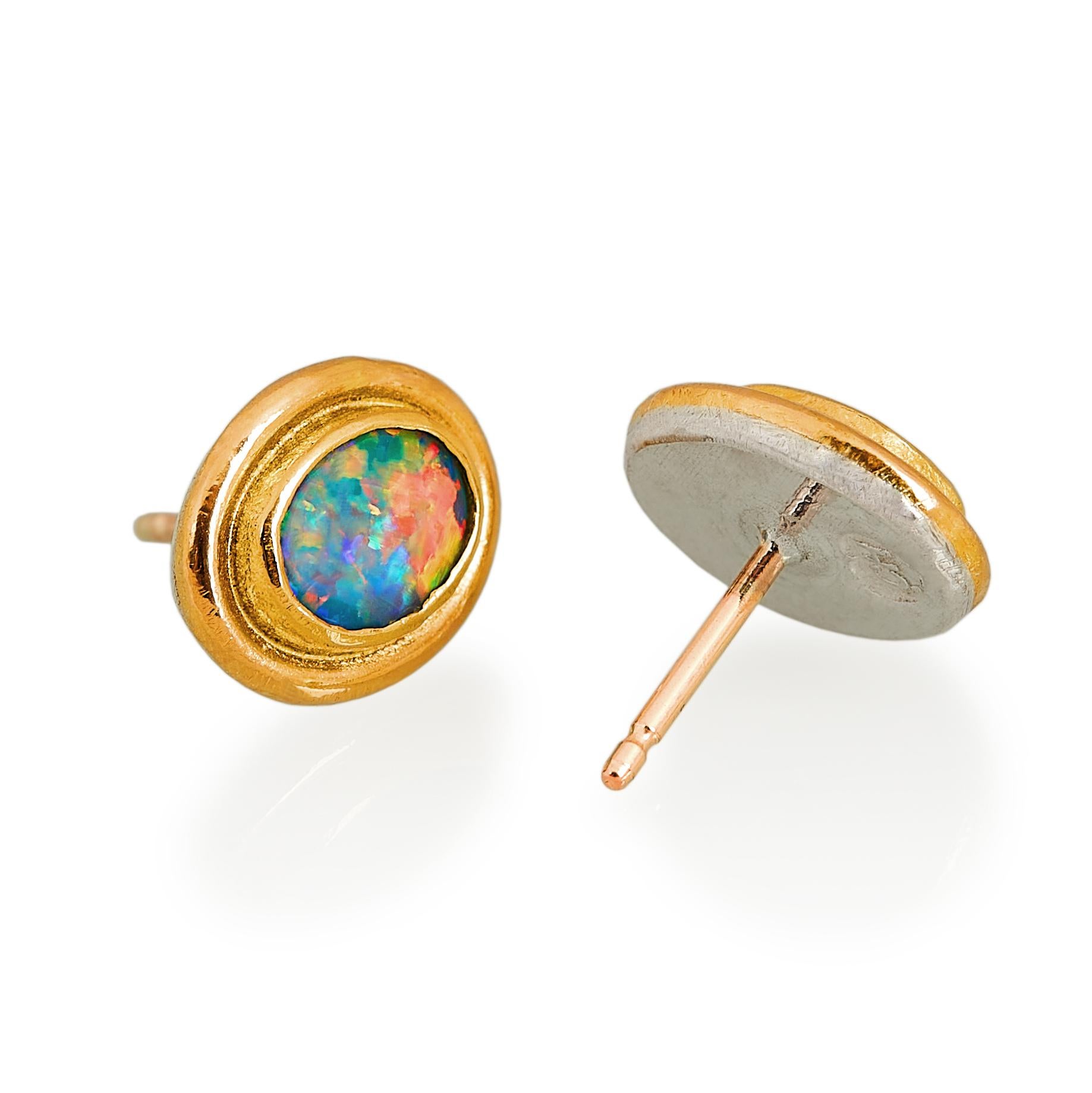 Handmade Charmian Harris stud earrings that can easily worn on any occasion. They are made with bright doublet opals that refract almost all the colours of the rainbow. The opals are set in ample 22 karat gold which is backed on silver and they have