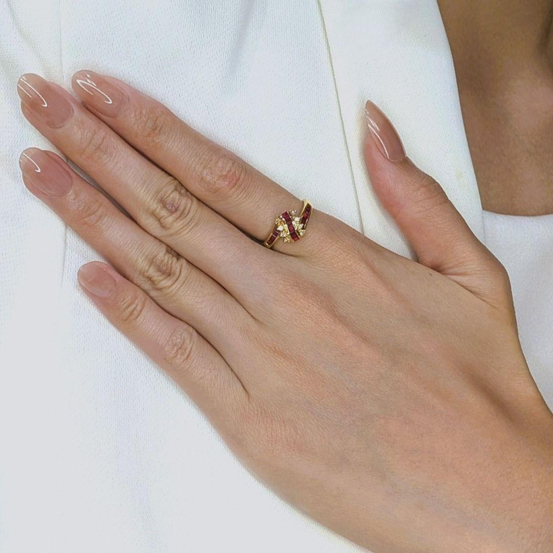 This stunning ring radiates luxury and timeless charm with its 18K yellow gold setting, perfectly complementing 15 princess-cut rubies totaling 0.76 carats. The rich red hues of the rubies are beautifully accented by eight round brilliant-cut