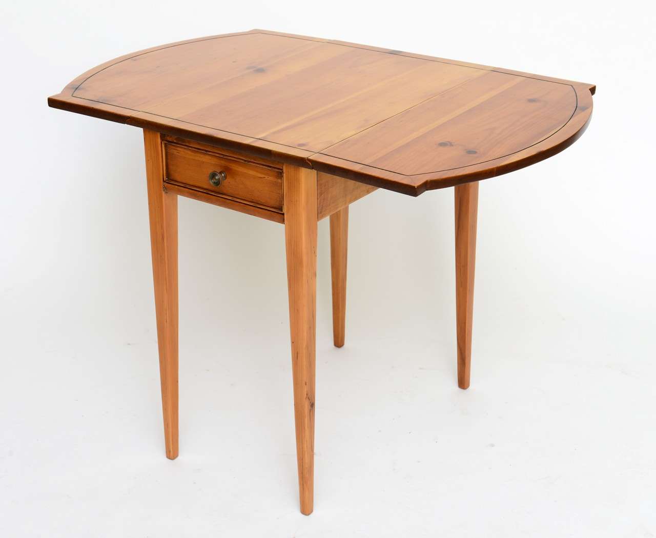 Reduced from $985.
From the 19 40s, this Pembroke drop-leaf table was made in Maryland by Brandt. Constructed of pine, it features a single beaded drawer and incised faux stringing on the top creating a banded like edge. The drop leafs have a