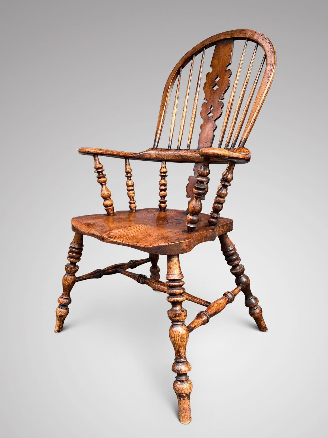A beautiful elm broad arm Windsor chair, superb quality 19th Century, high back with central fretted decorative splat and turned spindles, with elm seat with a three piece arm bow sitting on nicely turned legs connected by a H-stretcher. Lovely