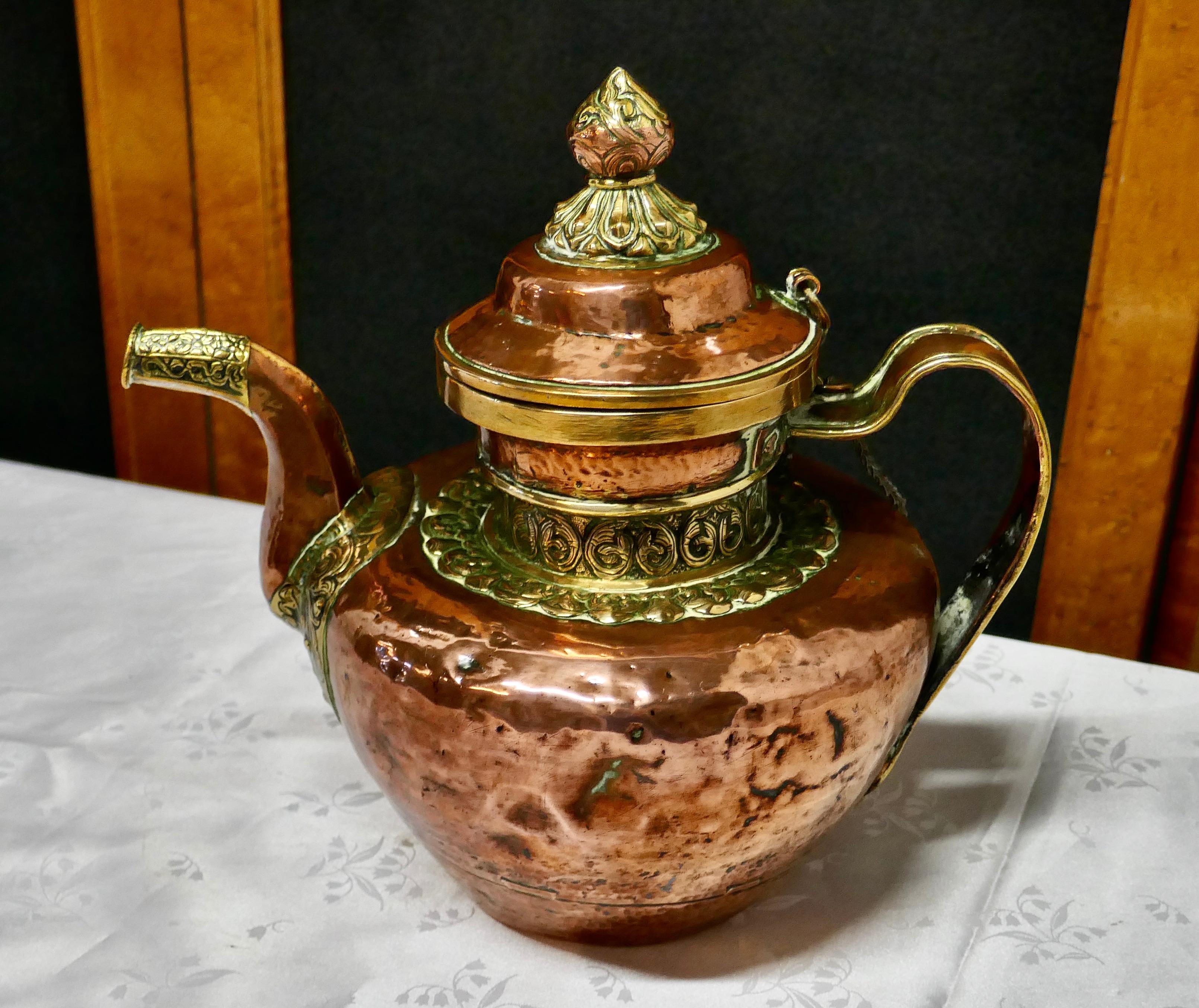 Charming 19th century Indian beaten copper and chased brass tea pot

A delightful piece, handmade in the Indian way, the copper is hand beaten and the brass is finely chased around the spout and lid, there is a chain attached to both the lid and
