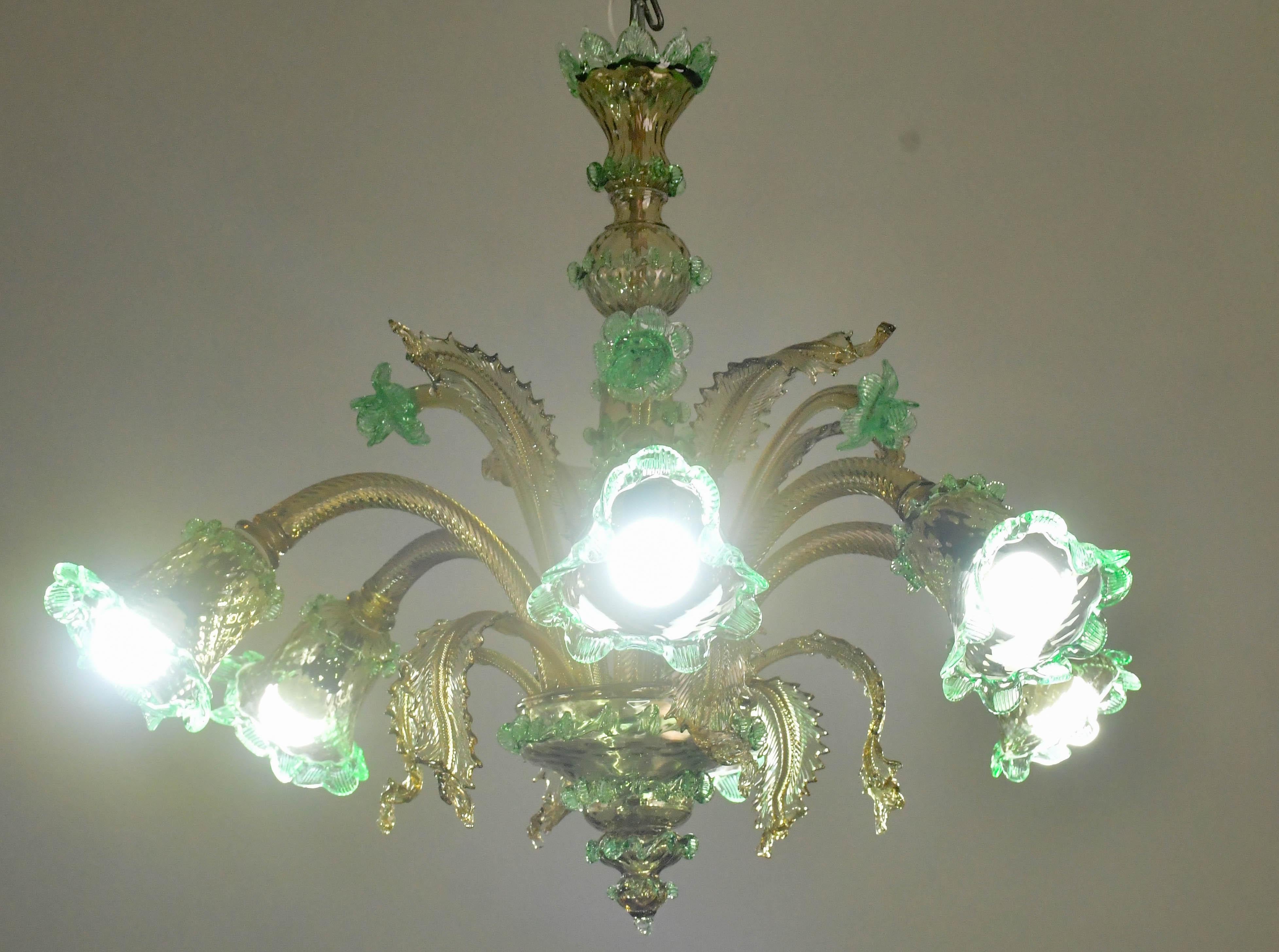 Joli lustre de Murano, typiquement vénitien classique, de couleur verte.

Le lustre a 6 bras qui montent 6 points lumineux e14, normes européennes, possibilité de recâblage pour les USA.

La fixation comporte 6 feuilles basses, 4 fleurs hautes et 4