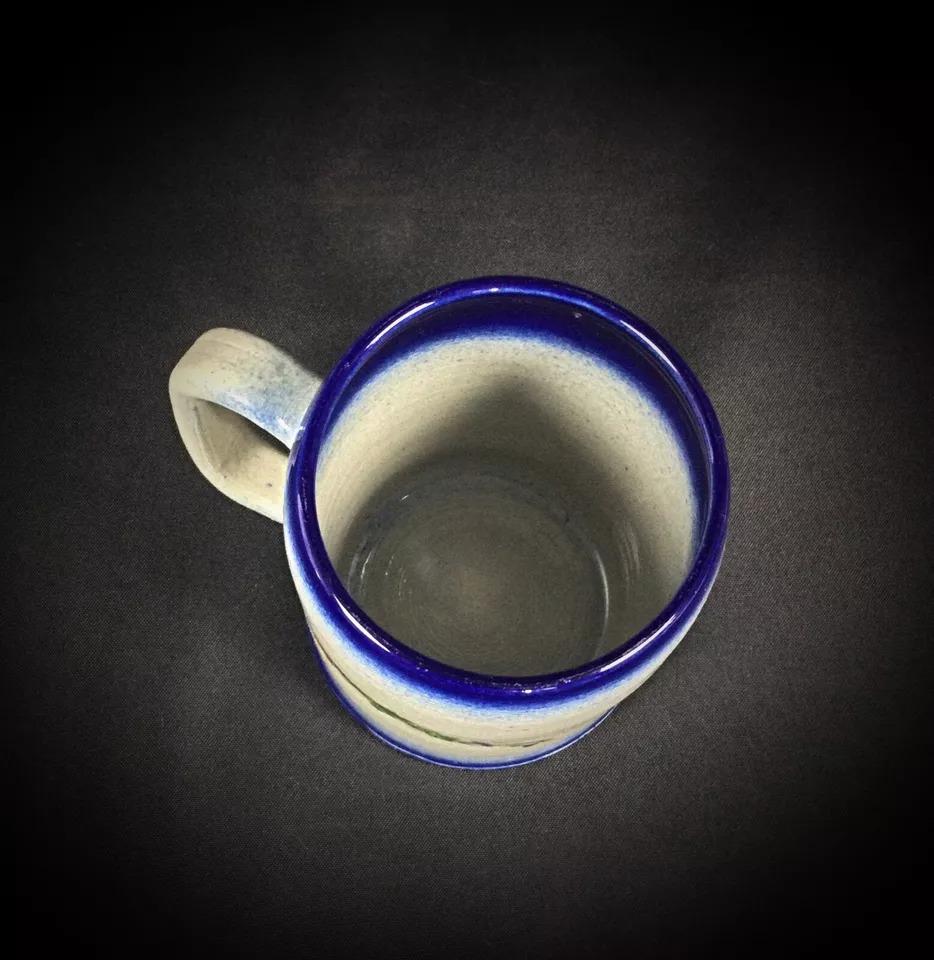 Diese bezaubernde Tasse aus elsässischem Steingut, signiert von Anne Ehret, ist ein entzückendes Stück, das sich durch exquisite Handwerkskunst und traditionelles Design auszeichnet. Diese Tasse ist ideal für Sammler und Liebhaber feiner Töpferwaren