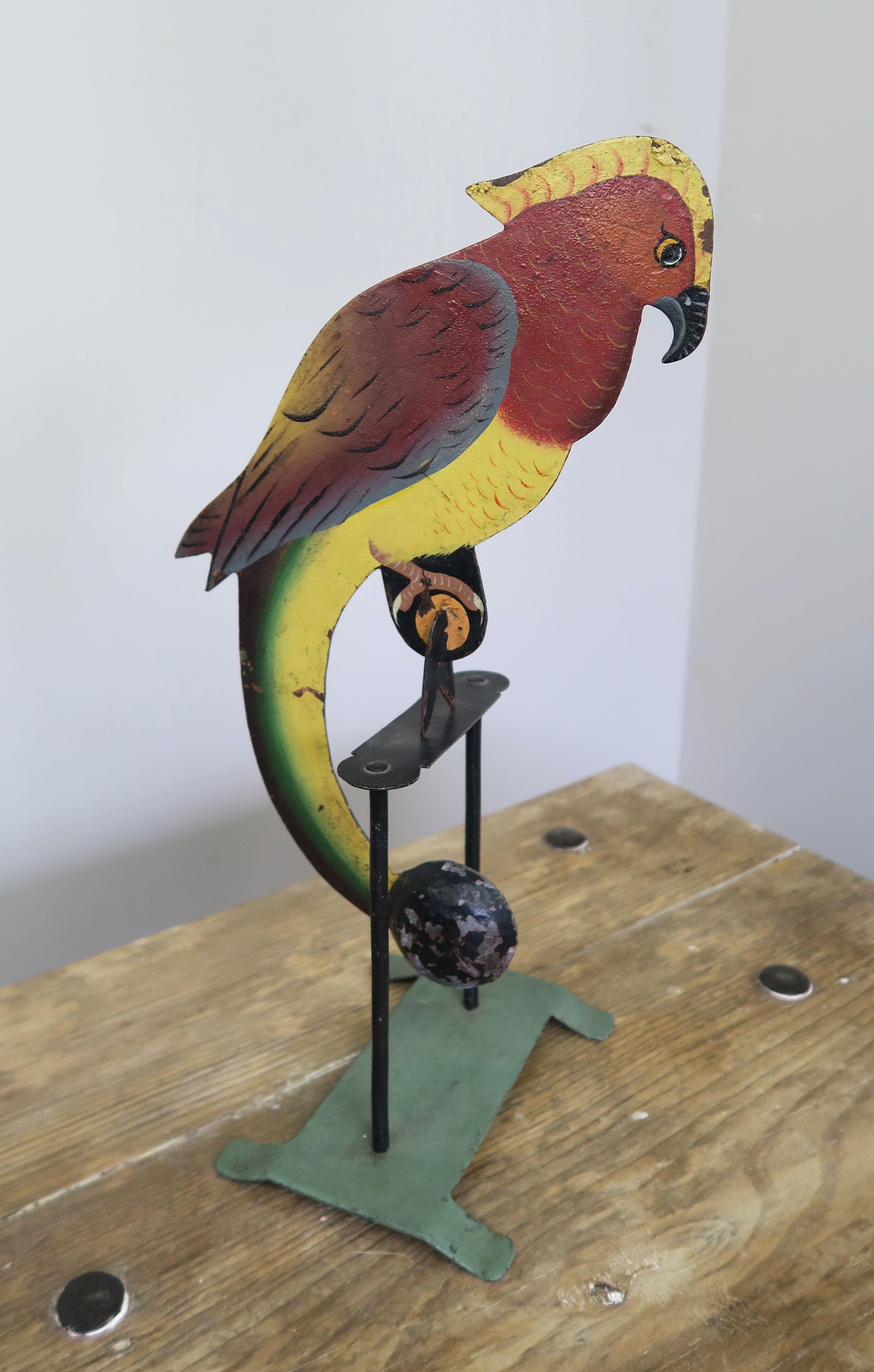 Charming American folk art piece depicting a balancing parrot perched on his stand. The parrot is perfectly weighted so with a small push he can swing beautifully on his base for fun entertainment for the whole family. They also are collectible.