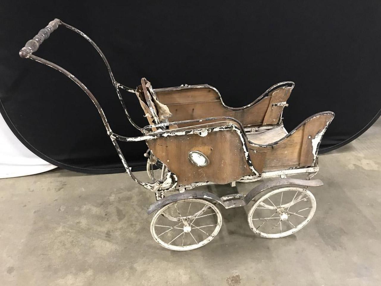Antique baby carriage constructed of metal and wood, the buggy makes a wonderful doll stroller, use in a garden for plant display, plant stand or garden decoration.