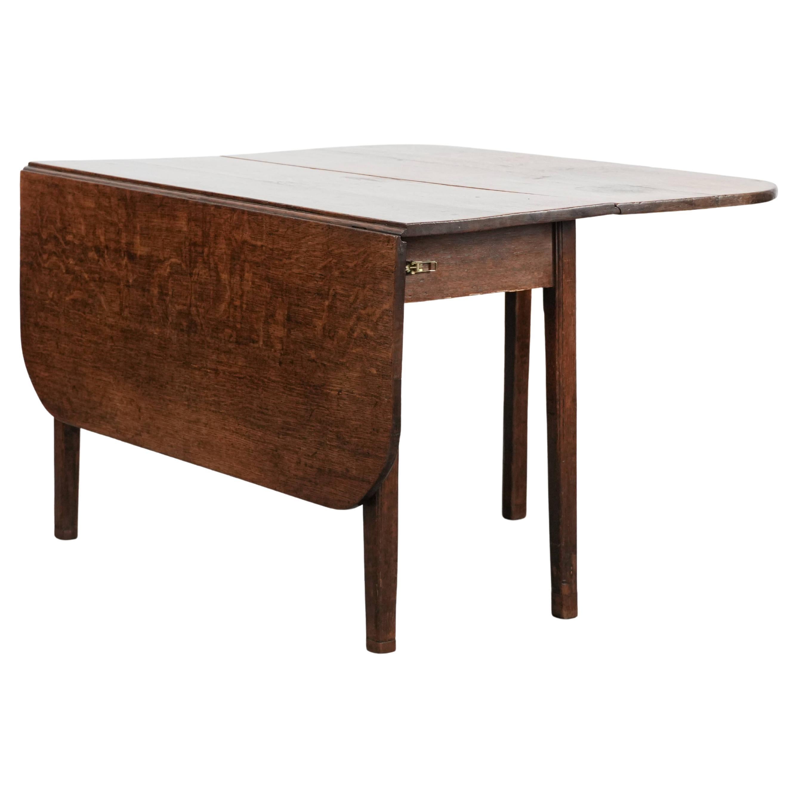 Charming antique English drop-leaf dining table made of oak, the late 19th cent