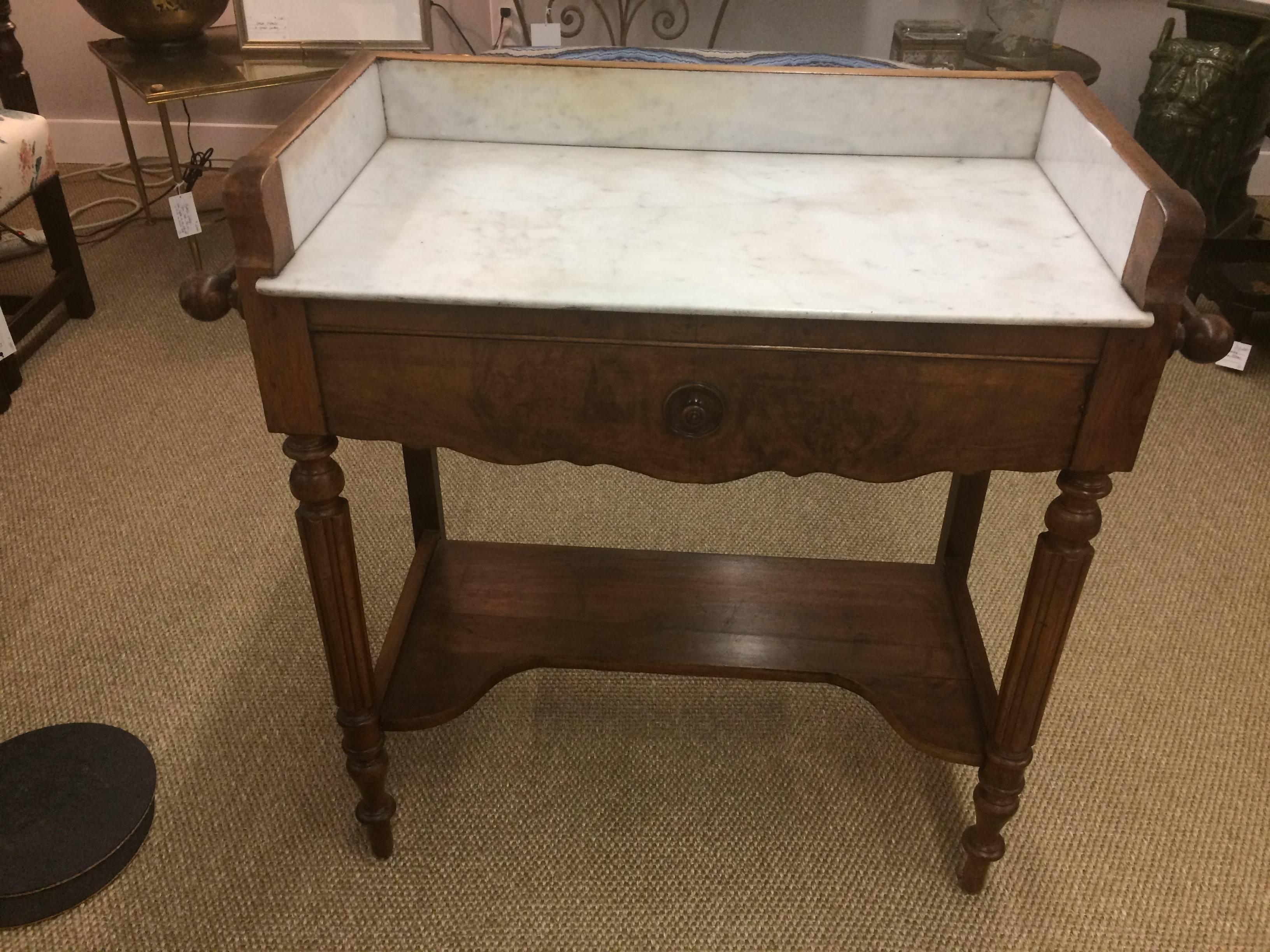 A wonderful rare find originally meant to be a kitchen mixing table, versatile for it's marble gallery, single drawer, and towel racks on either side. Gorgeous grained mahogany and pretty belly button of a pull on the drawer.