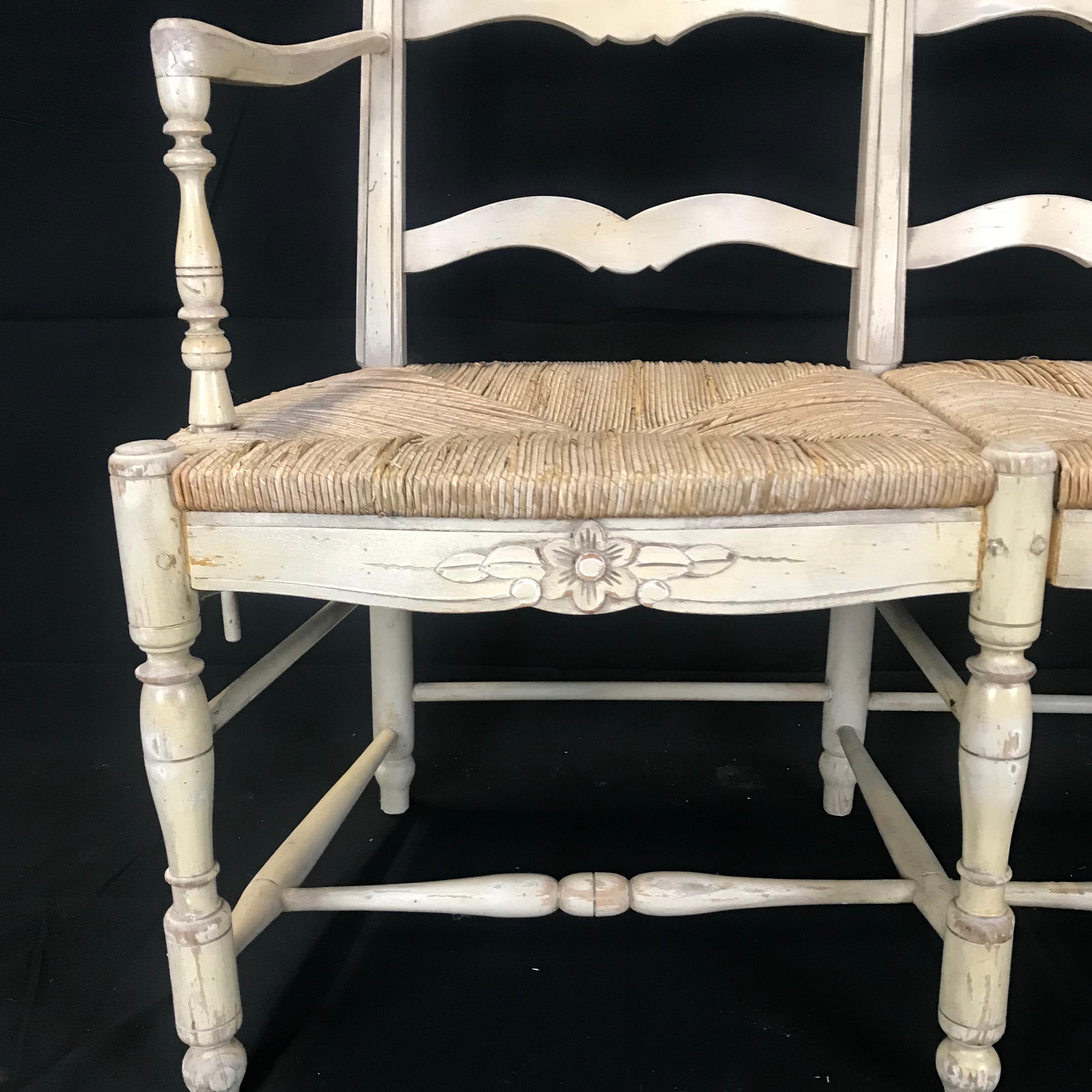19th century French country loveseat sofa or bench carved to perfection with a floral motif and retaining its original neutral colored cream paint, having six turned legs and stretchers,
 circa 1880s.
#4342
Measures: Seat 17.5” x H arm 27.75”.