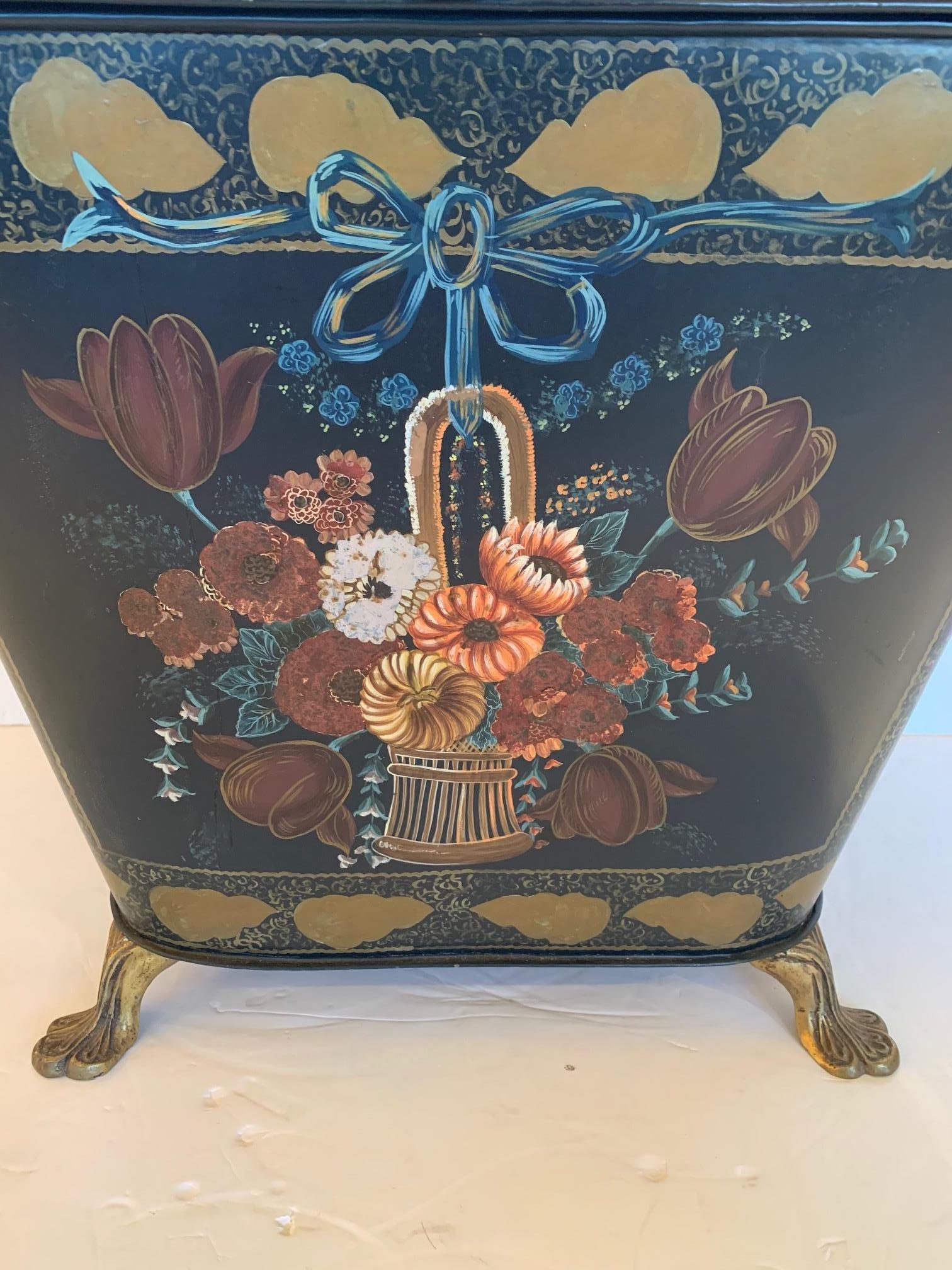 A wonderful vintage hand painted tole coal scuttle having black background and earth color floral decoration, very ornate brass handles and charming brass feet.
  