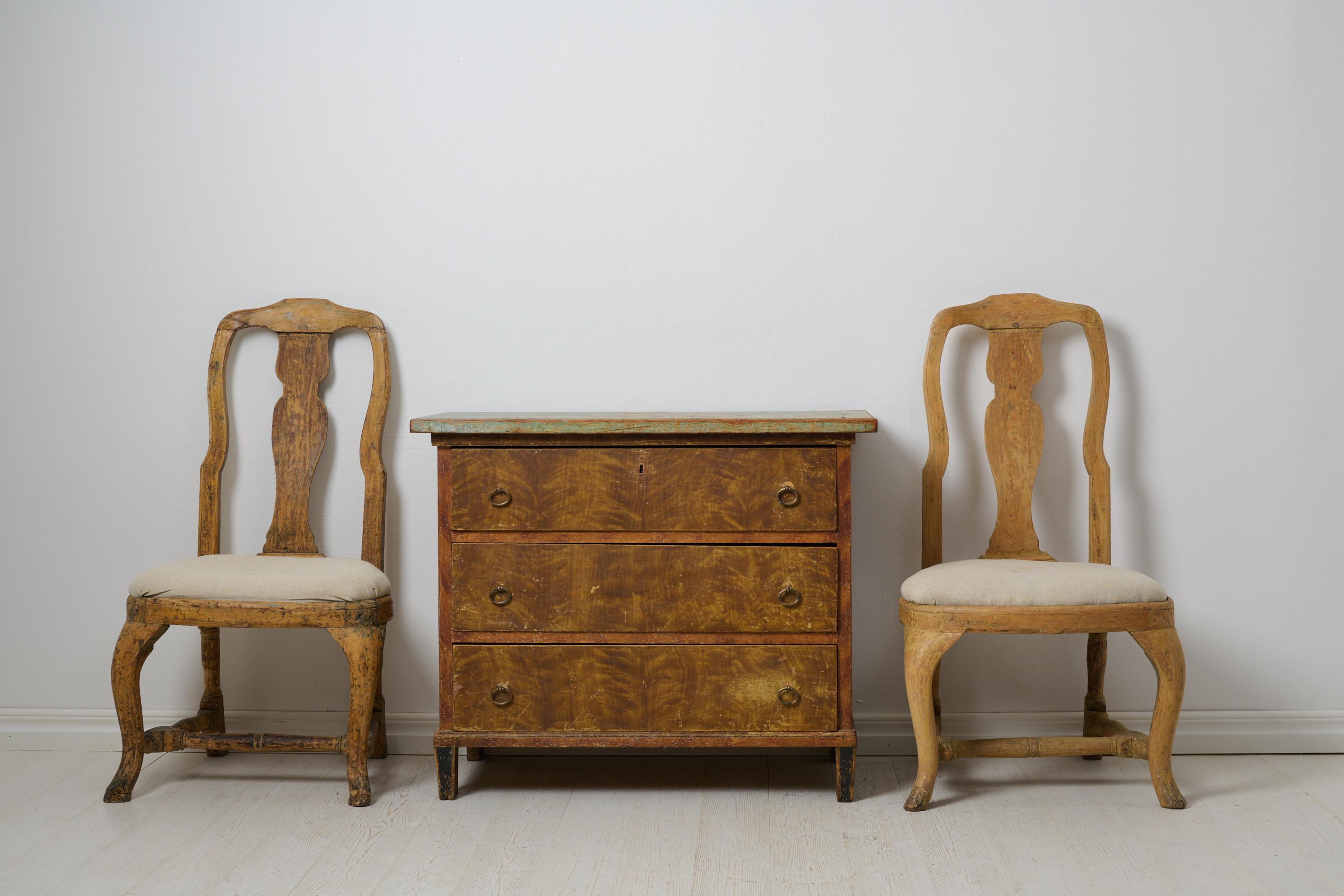 Charmante commode suédoise ancienne en pin massif avec trois tiroirs fonctionnels. Le coffre est un véritable meuble de maison de campagne du centre de la Suède, fabriqué vers les années 1840. Il possède une peinture d'origine qui, après 200 ans