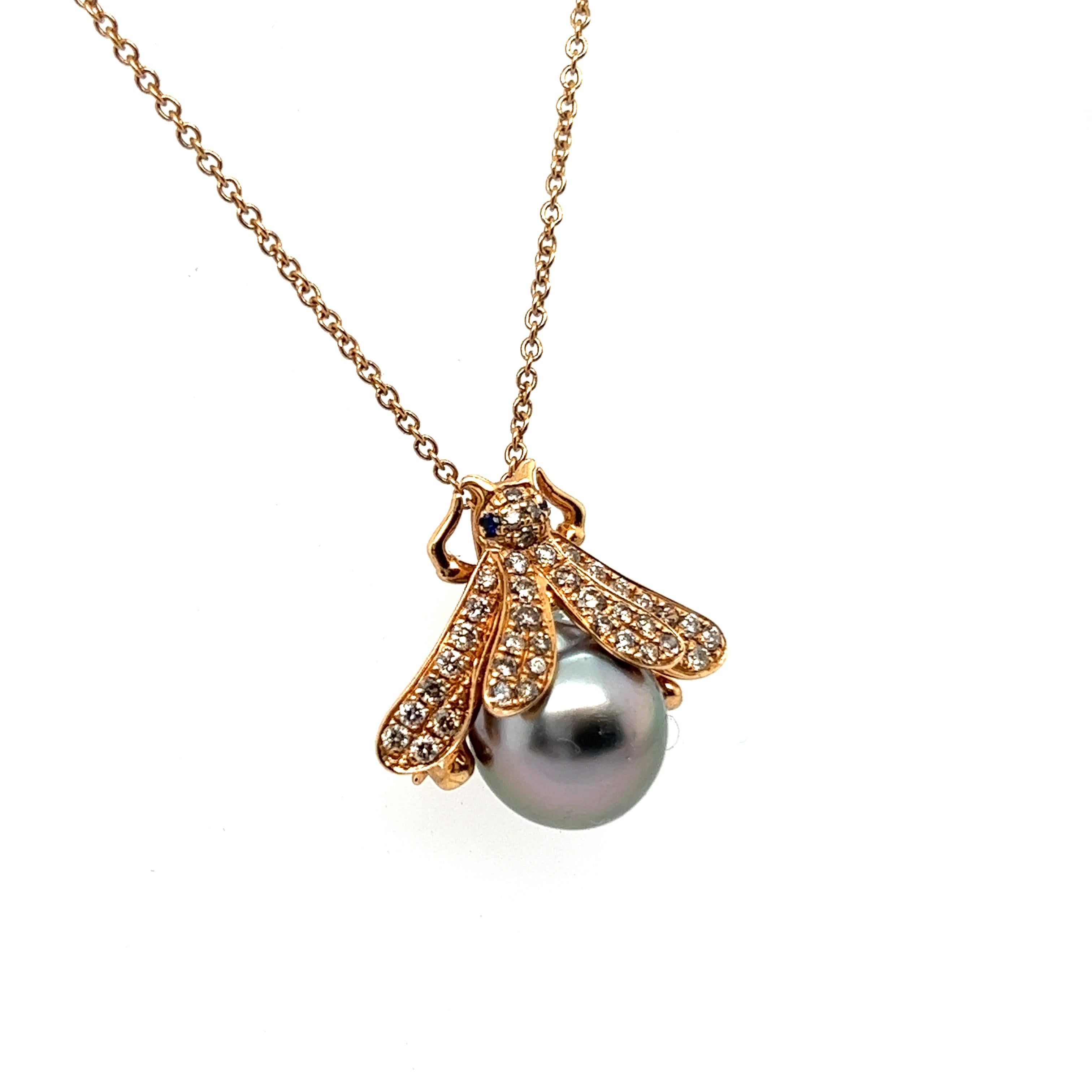 Presenting charming bee-shaped pendant with a pearl and diamonds in 18 Karat red gold.

The petite body of this little bee is crafted from a cultured grey Tahitian pearl, imparting timeless elegance. Its wings are adorned with 40 brown si clarity