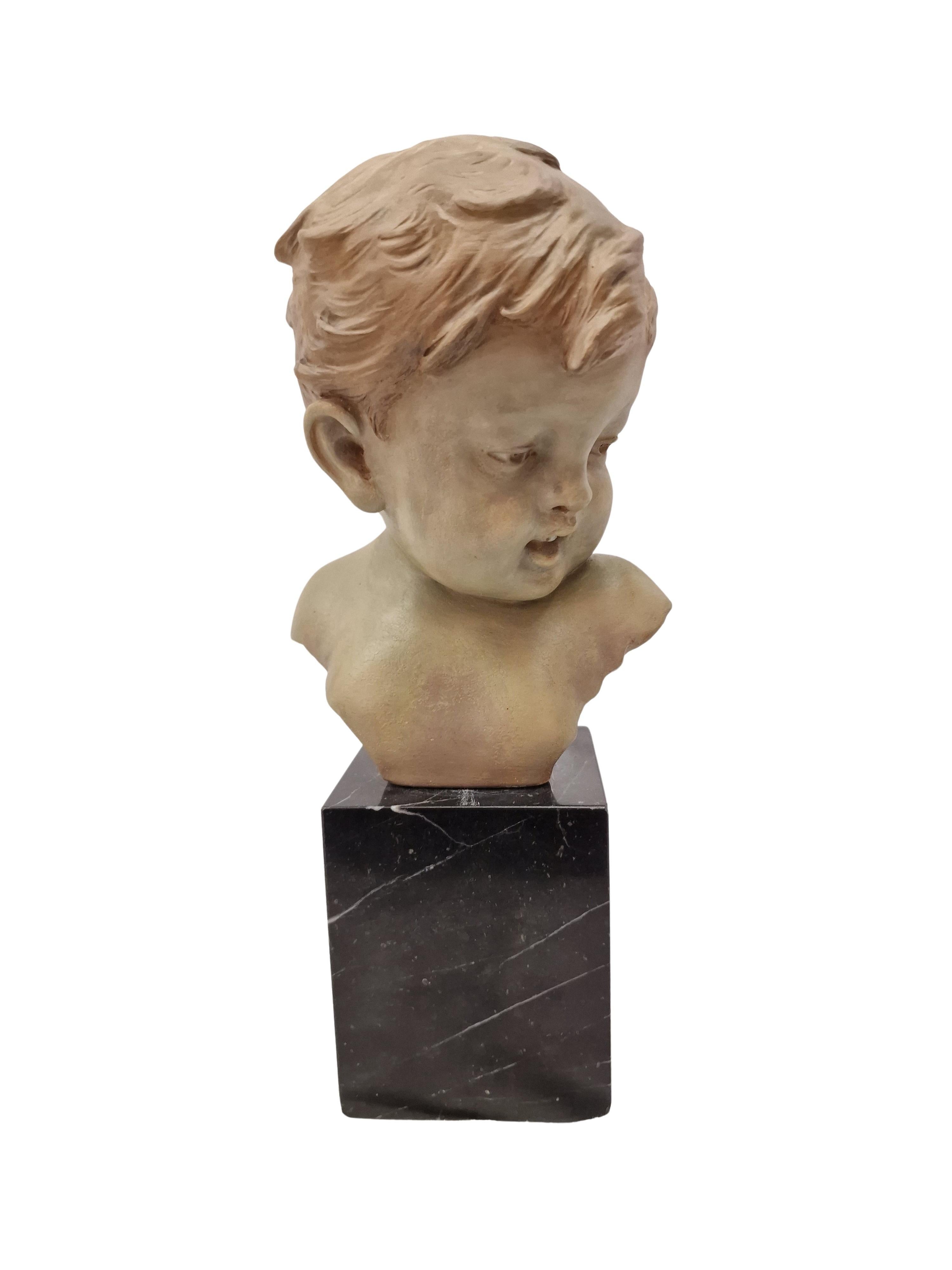 Rara representación particularmente bella de la de un niño. Creado por Gustave van Vaerenbergh bajo su seudónimo G. Carli en el periodo Art Déco. 

Esta terracota fue policromada a mano, lo que resalta bellamente los finos rasgos faciales. El color