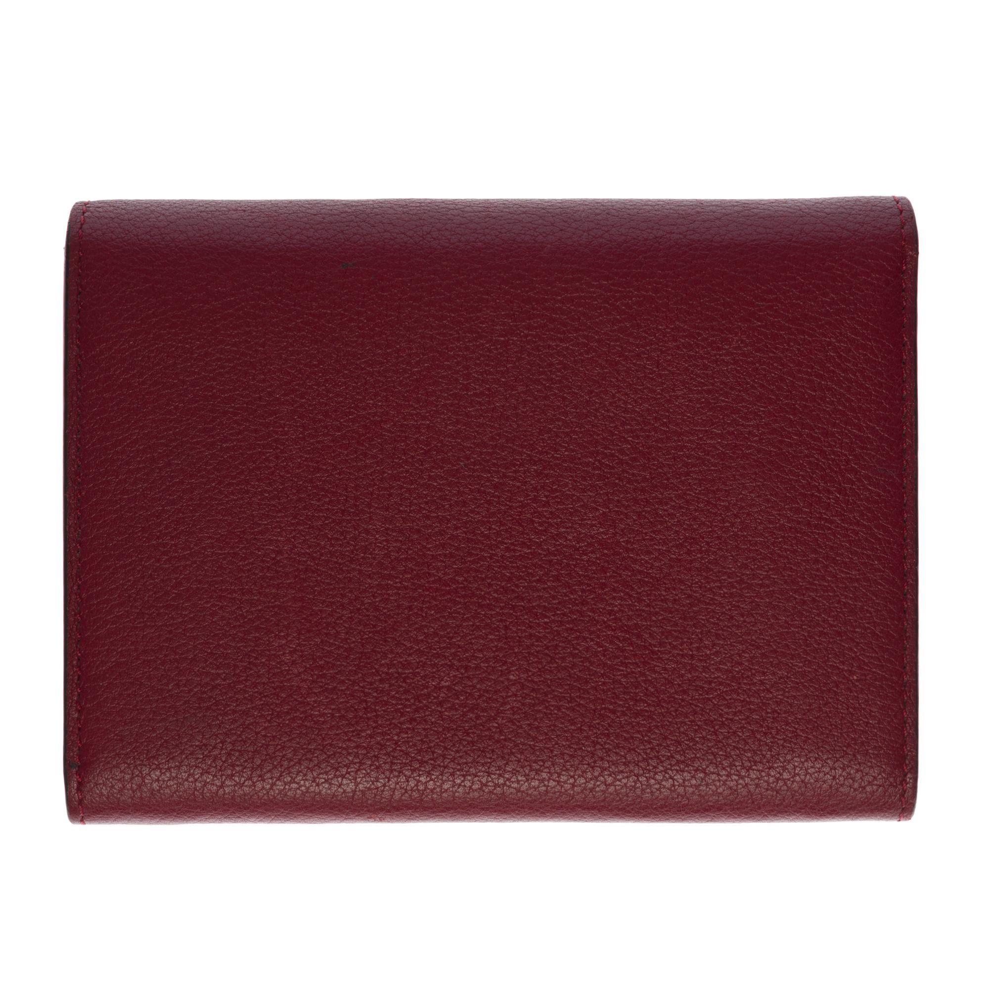 Sehr schöne Cartier-Brieftasche aus bordeauxfarbenem Leder:: vergoldete Metallbeschläge. 
Verschluss durch Klappe und Druckknopf. 
6 Kartenfächer. 
1 Münzfach mit Reißverschluss
Signatur: 