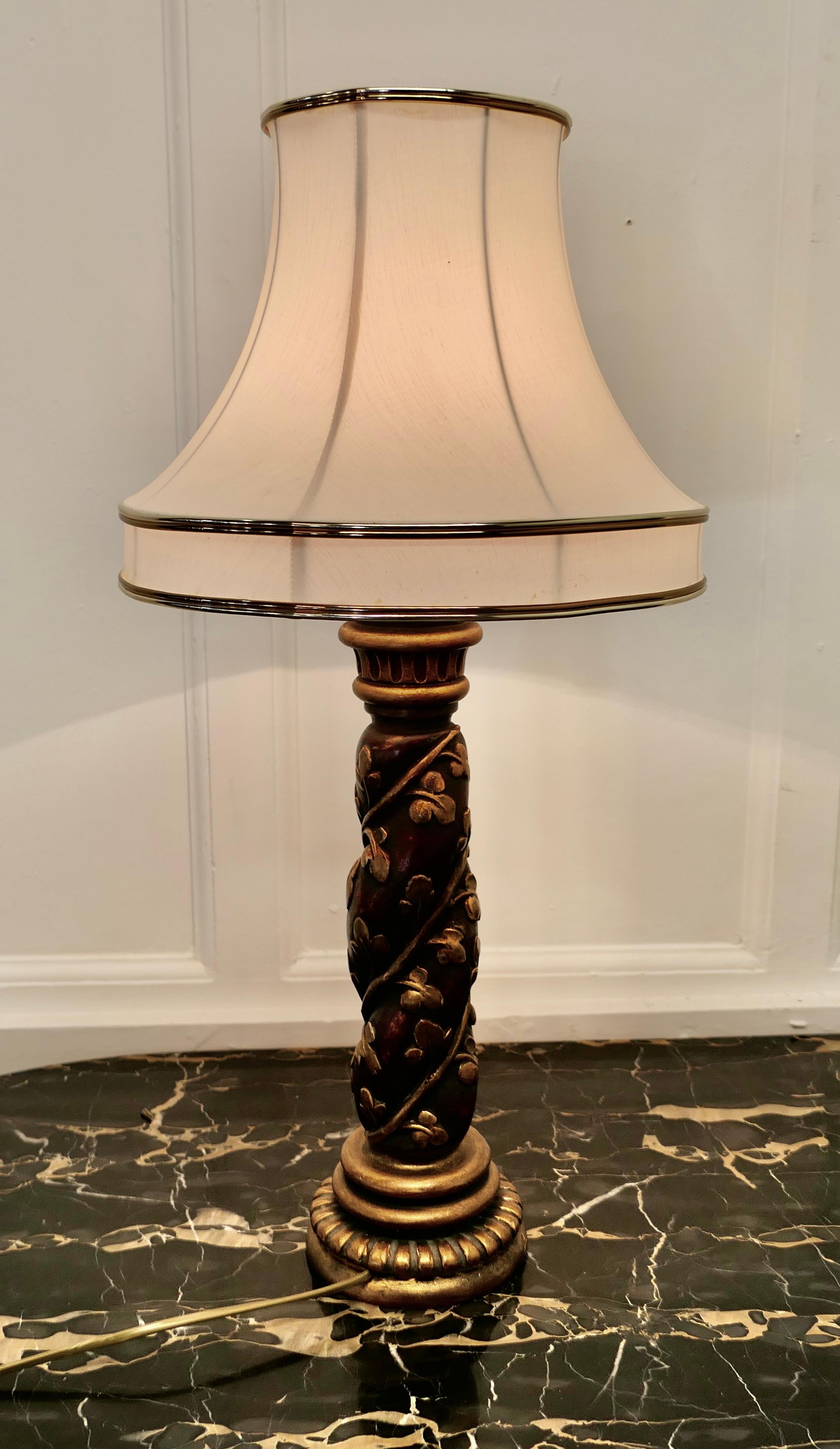 Charming carved and gilt baroque style lamp

This is a very decorative piece, with its delicate lined linen and brass Lamp Shade, it is in burgundy red with carved golden vines twining around
The lamp is in good original condition, the wiring has