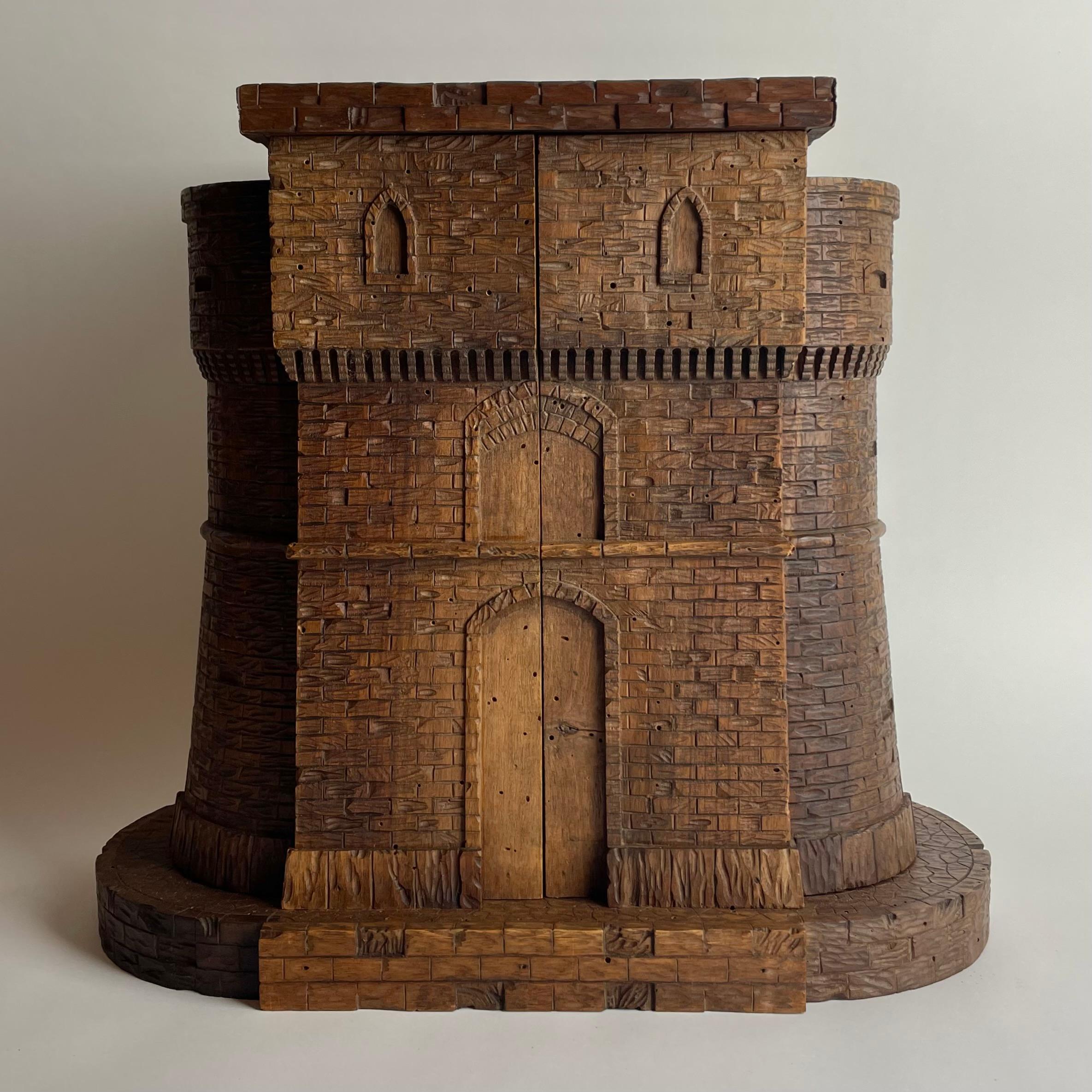 Carved Walnut Castle Form Liquor Cabinet, Late 19th Century

This whimsical and architecturally inspired castle-form cabinet is a charming example of late 19th-century craftsmanship, carved entirely from warm, richly figured walnut. Its turreted
