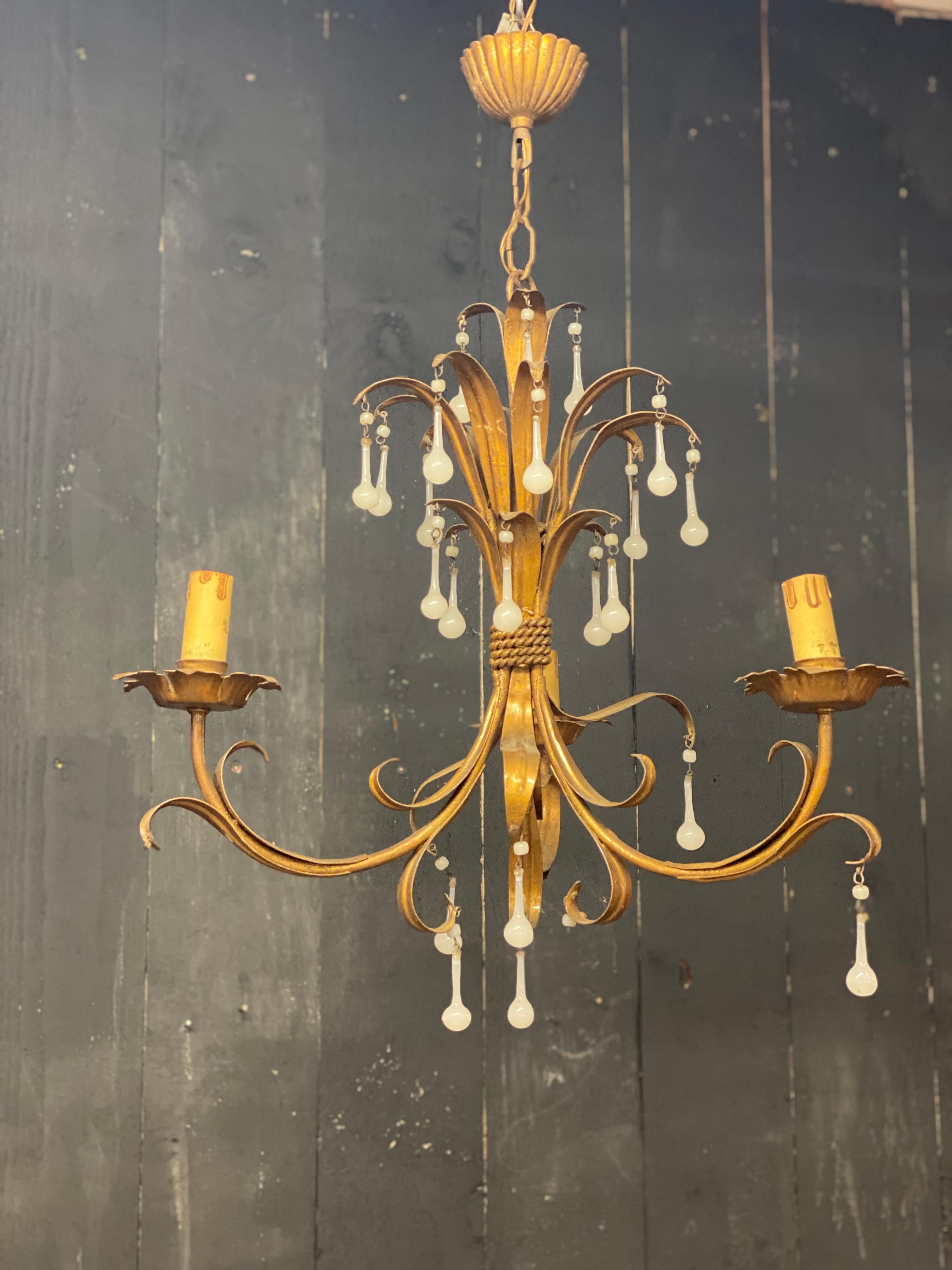 Affascinante lampadario in ferro dorato con pendenti opalini, circa 1950.
 