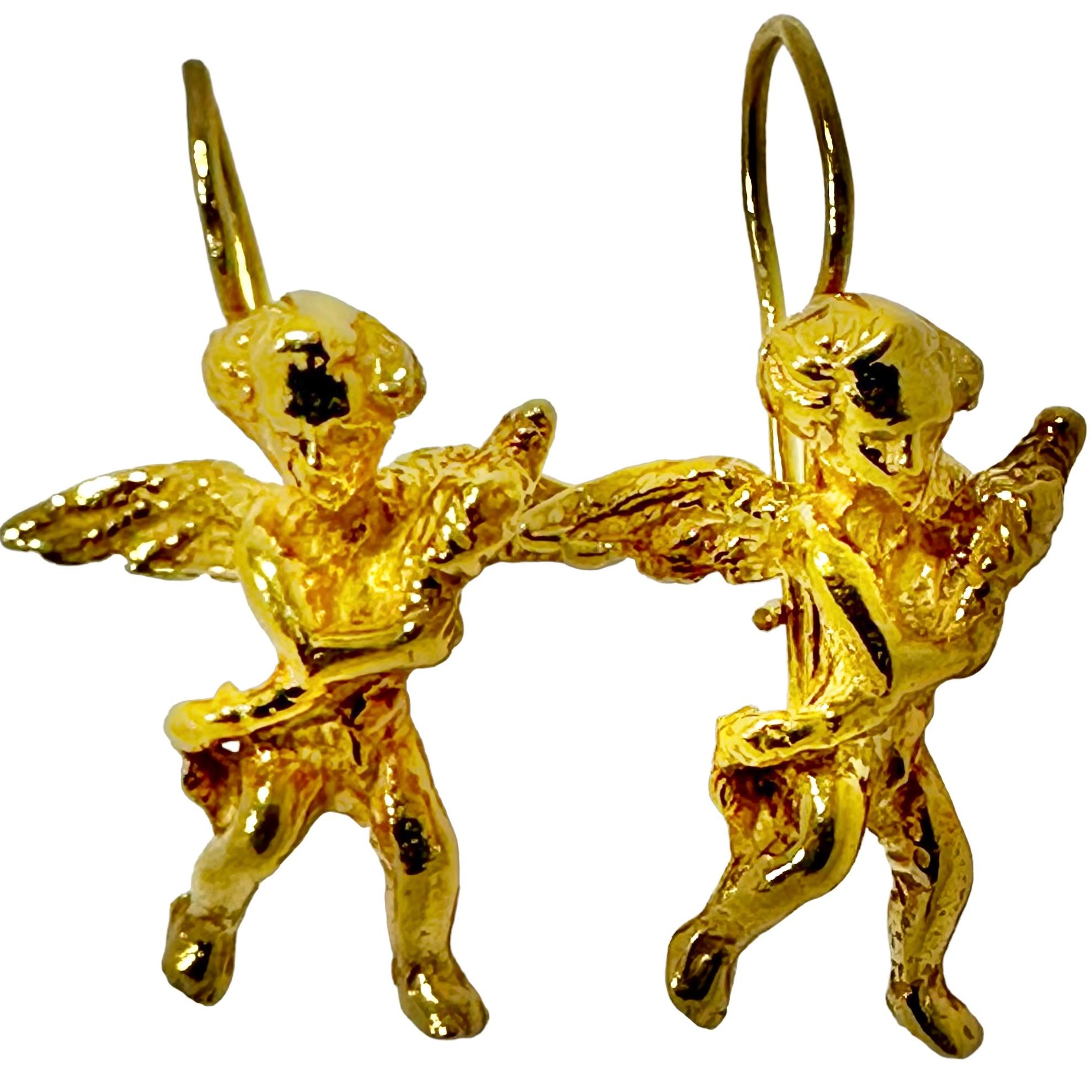 A pair of divine little cherubs. Created in 14K yellow gold, these mischievous little angels seem to be carrying an object in their arms. 
With a wingspan of 11/16 of an inch wide, and measuring 1 1/4 inches to the top of the ear wire, these cherubs